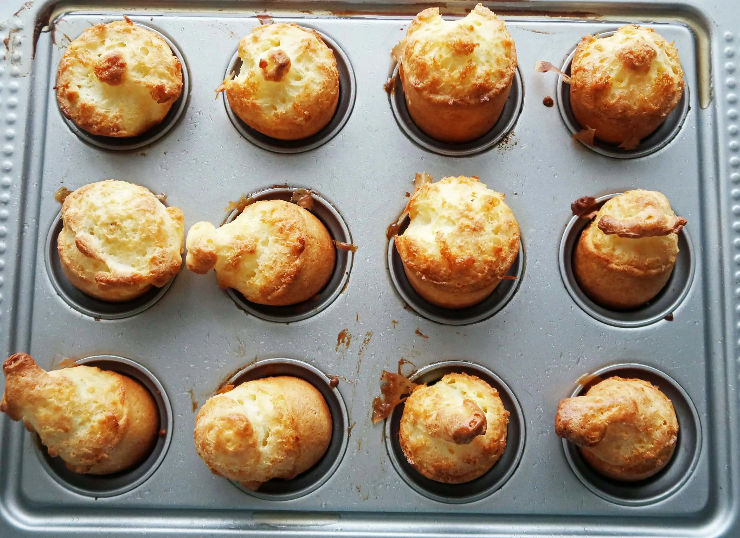 A pan of popovers with golden-brown tops.