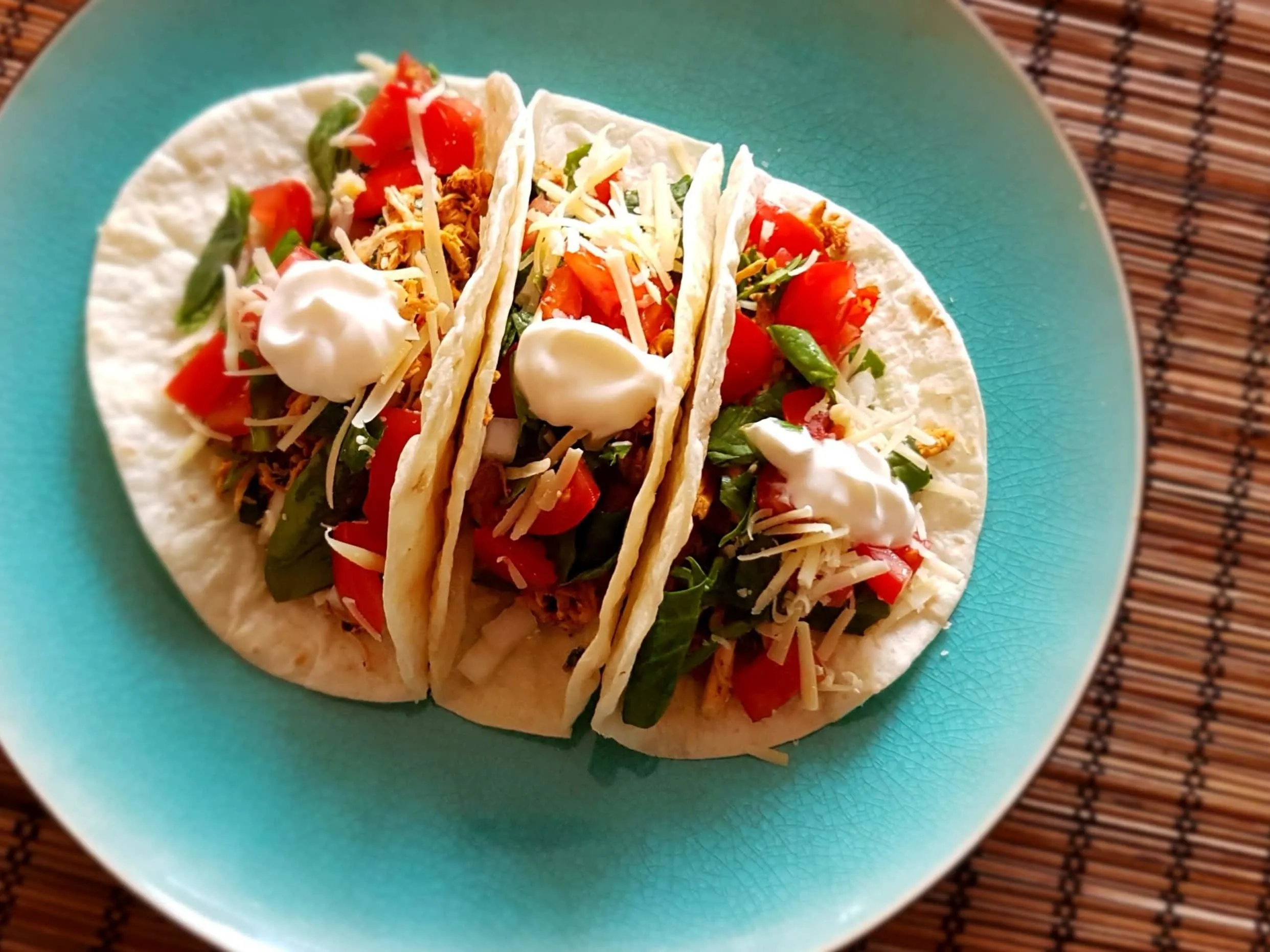 Three chicken taco on a plate.