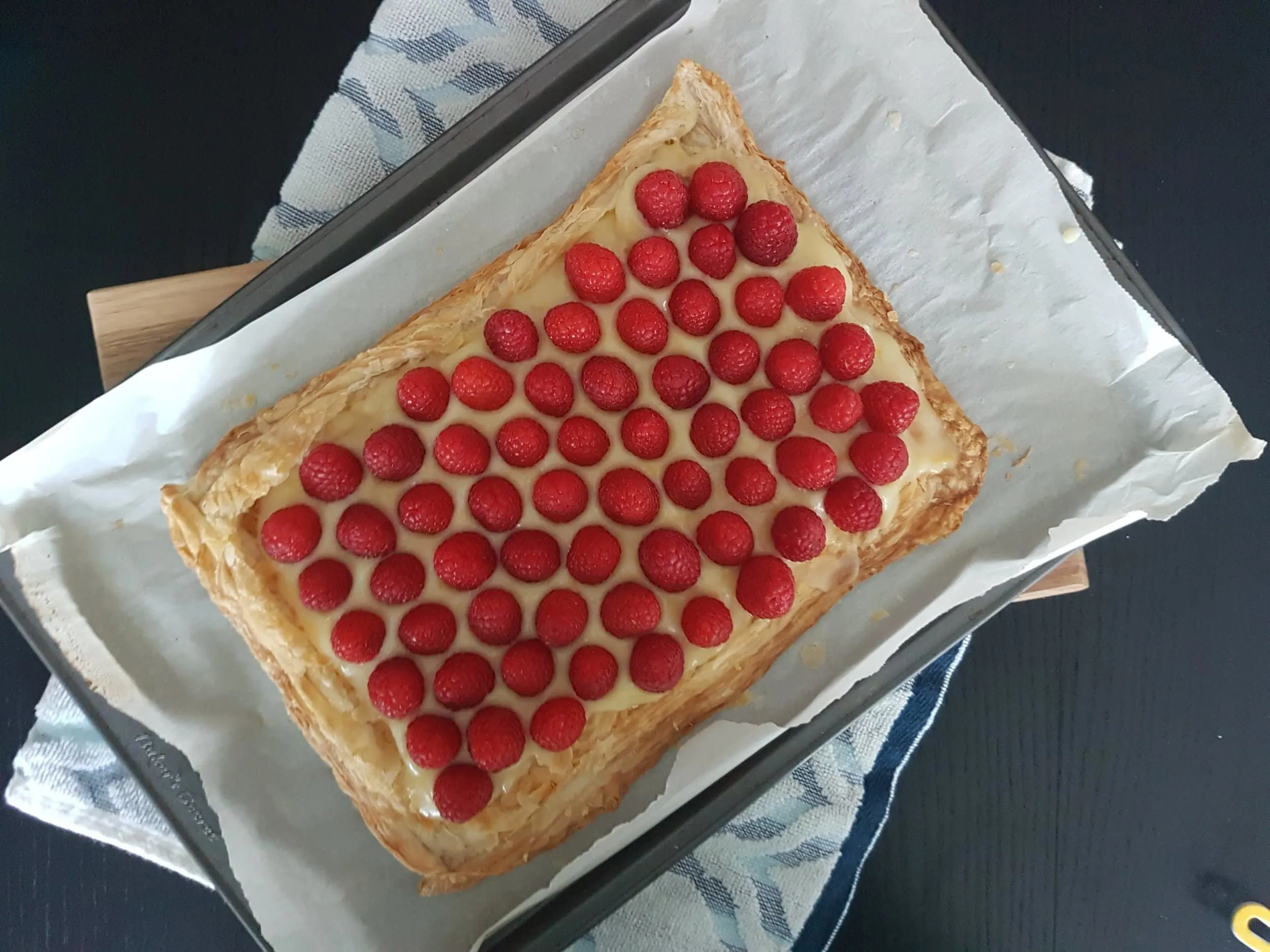 A Fresh Raspberry Lemon Curd Tart on a baking sheet.