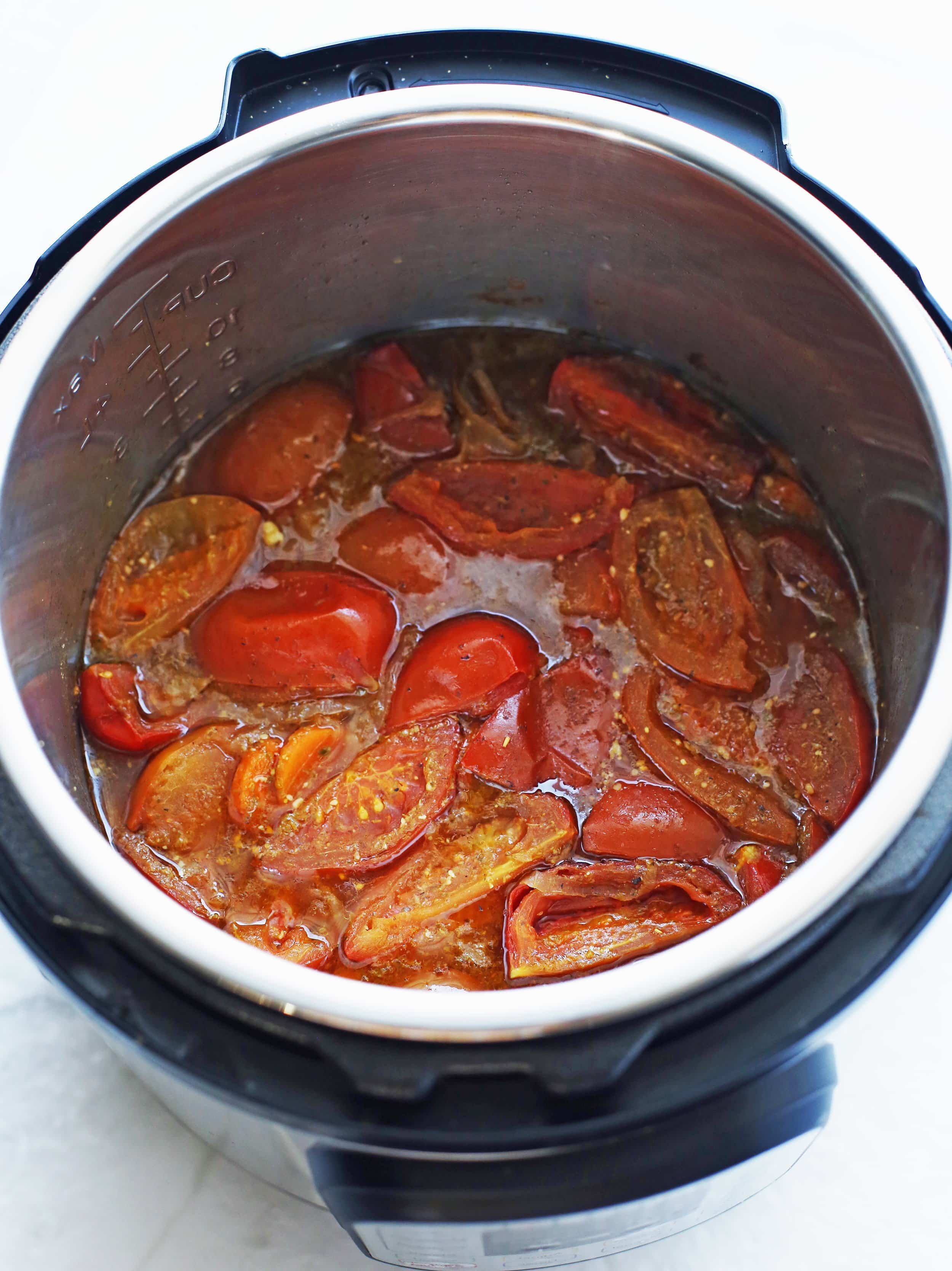 Onions, tomatoes, pesto, carrots, broth, and seasoning that have been cooked in the Instant Pot.