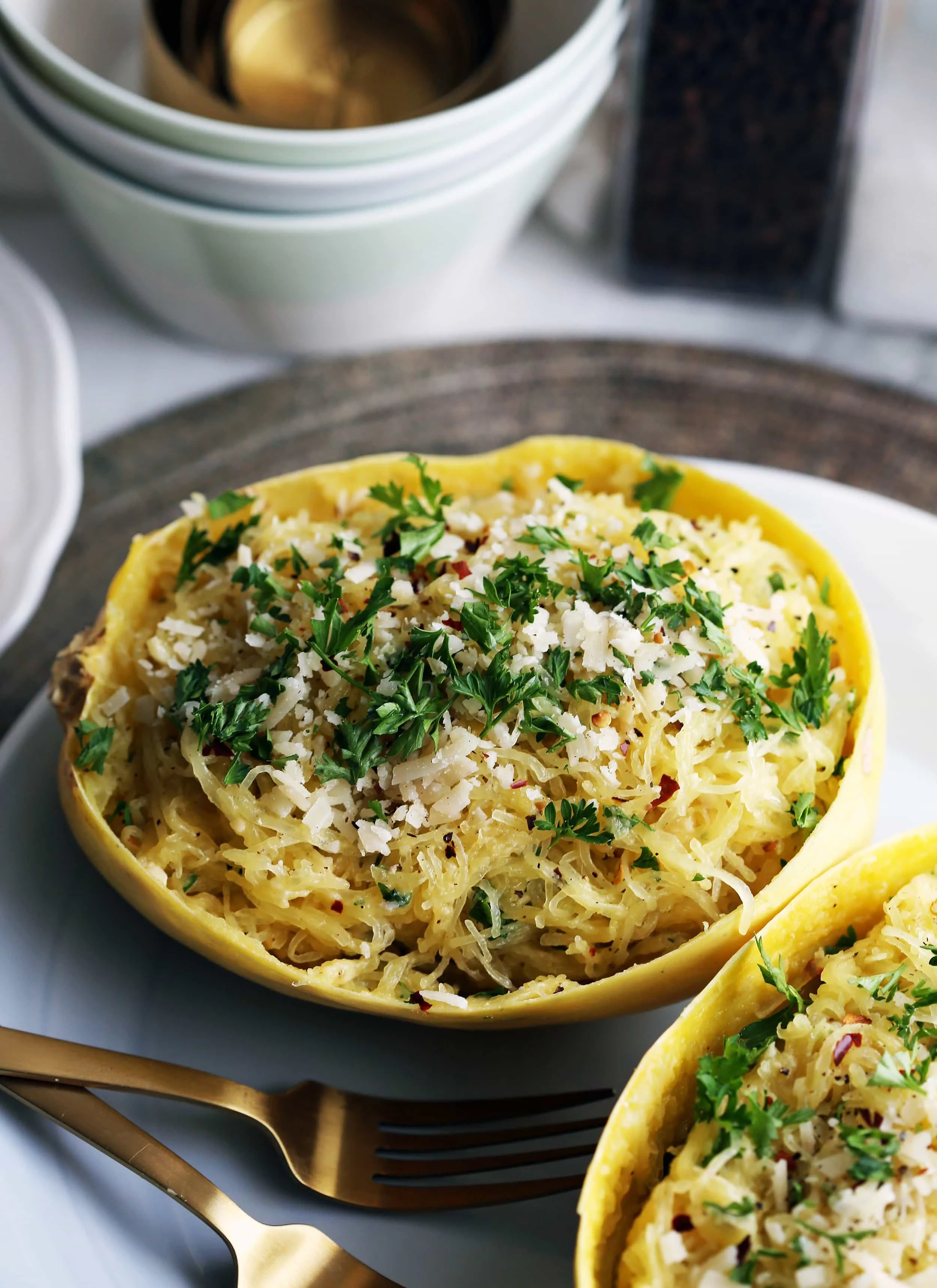 Instant Pot Garlic Parmesan Spaghetti Squash placed in a halved hollowed spaghetti squash shell (skin) with parsley on top.