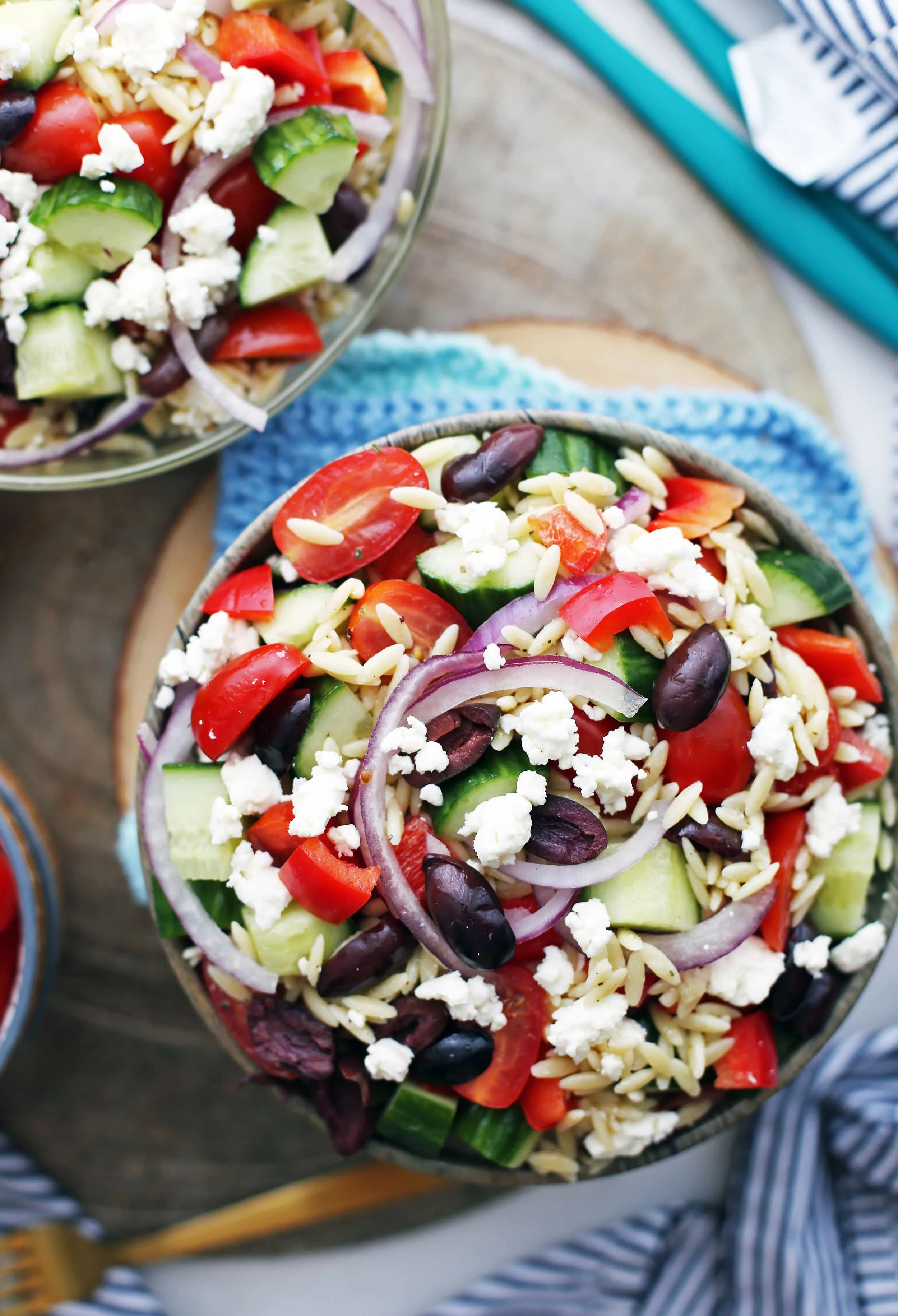 Overhead view of a brown bowl filled with Greek orzo salad.