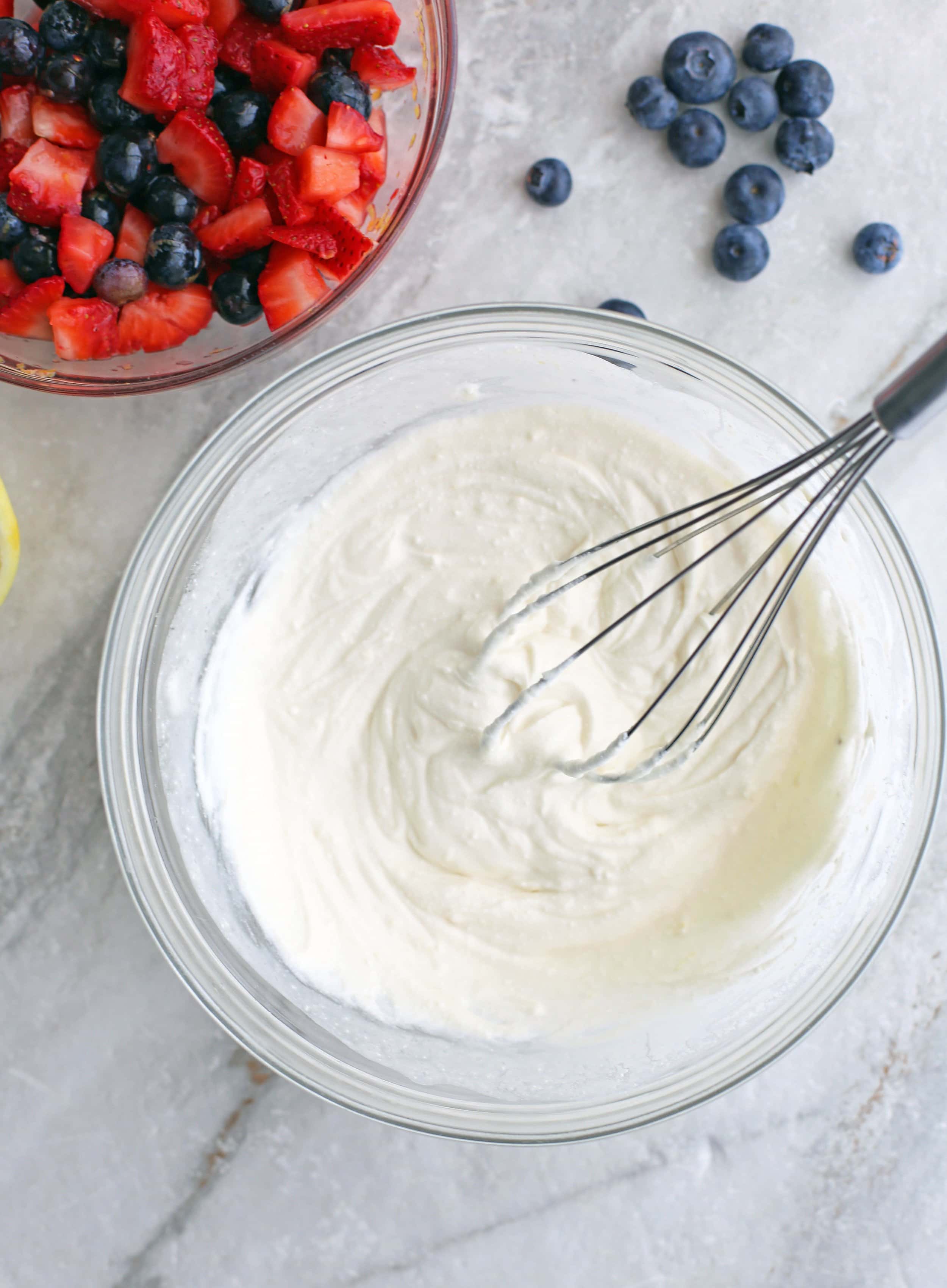 Mascarpone cheese, Greek yogurt, vanilla extract, honey, lemon juice and zest combined together in a glass bowl.