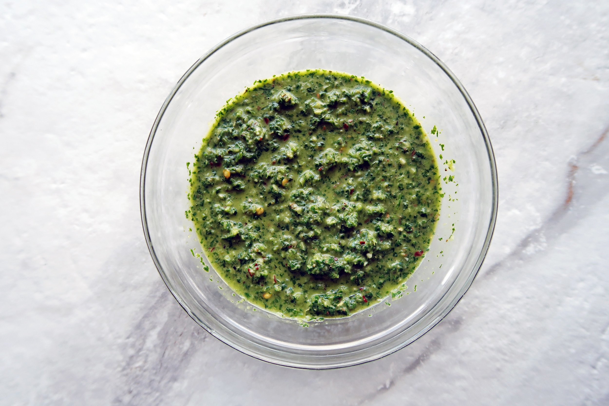 Freshly blended chimichurri sauce in a food processor.