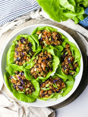 Overhead view of ground chicken lettuce wraps in a round grey bowl.
