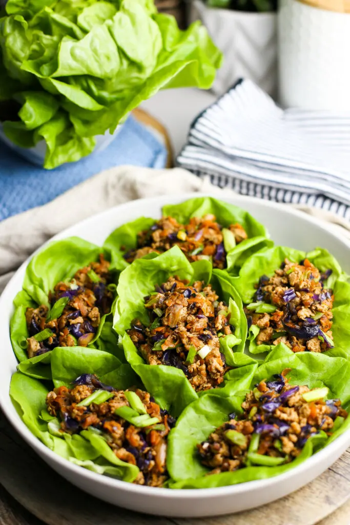 A grey platter containing six ground chicken lettuce wraps.
