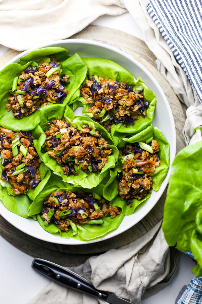 Overhead view of ground chicken lettuce wraps in a round grey bowl.