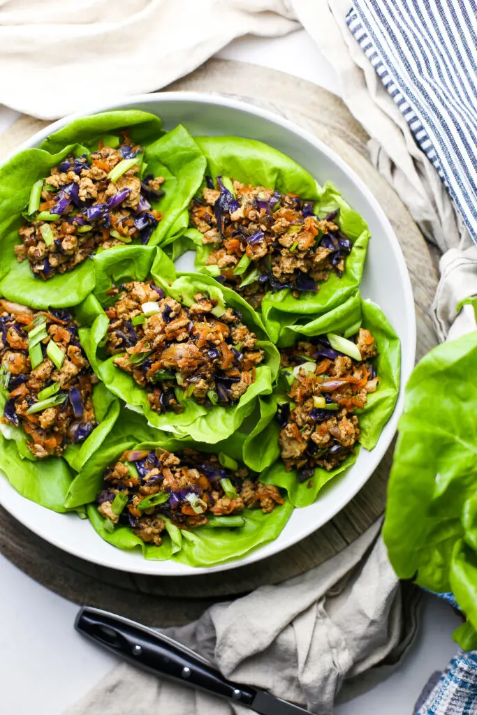 Overhead view of ground chicken lettuce wraps in a round grey bowl.