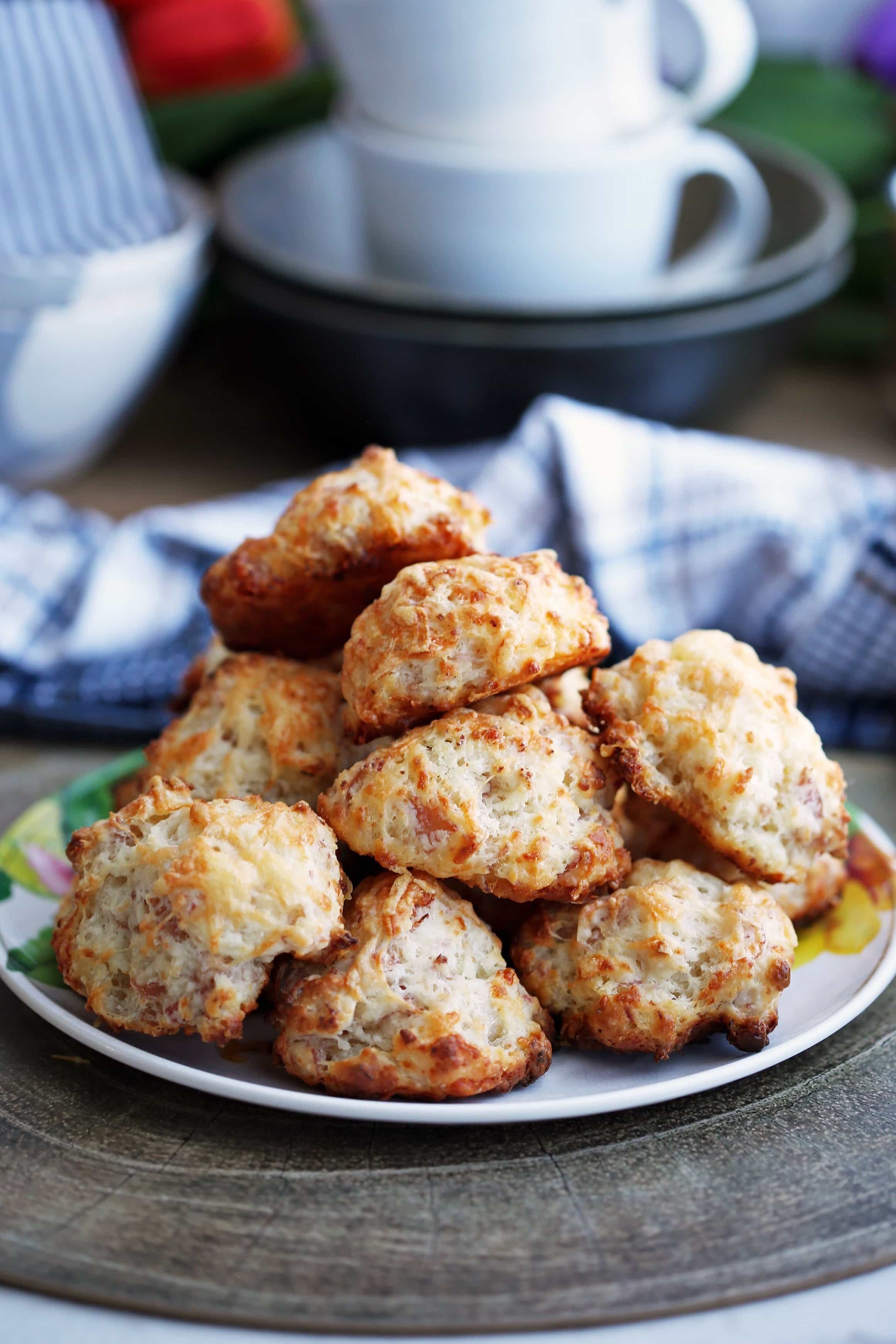Freshly baked ham and cheese drop biscuits piled on a colourful plate.