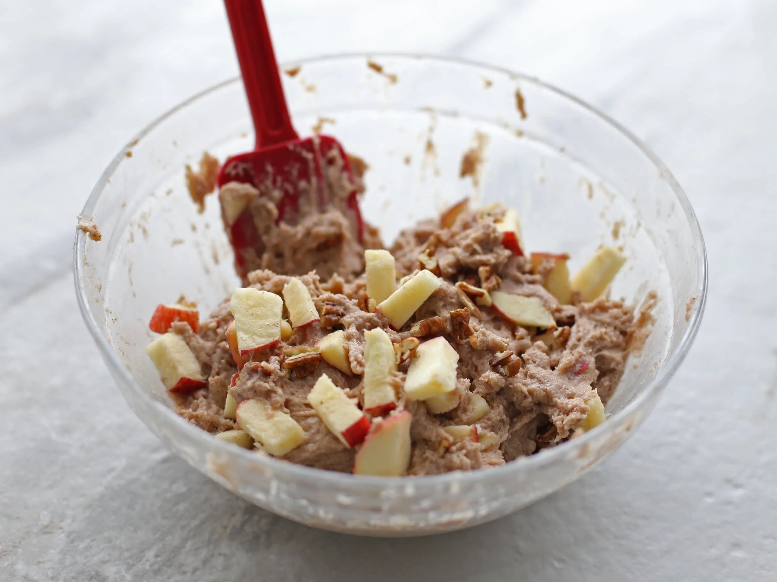 Apple cinnamon pecan cake batter in a glass bowl.