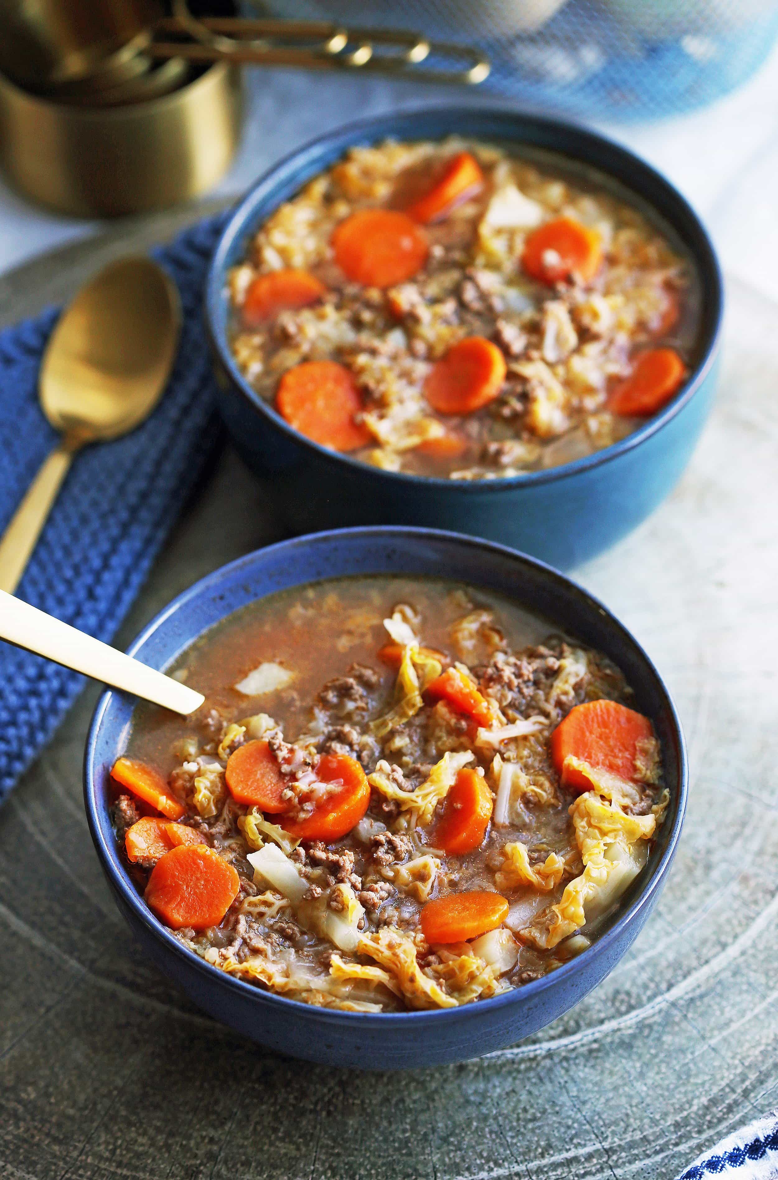 Instant Pot Beef and Cabbage Soup in two blue bowls.