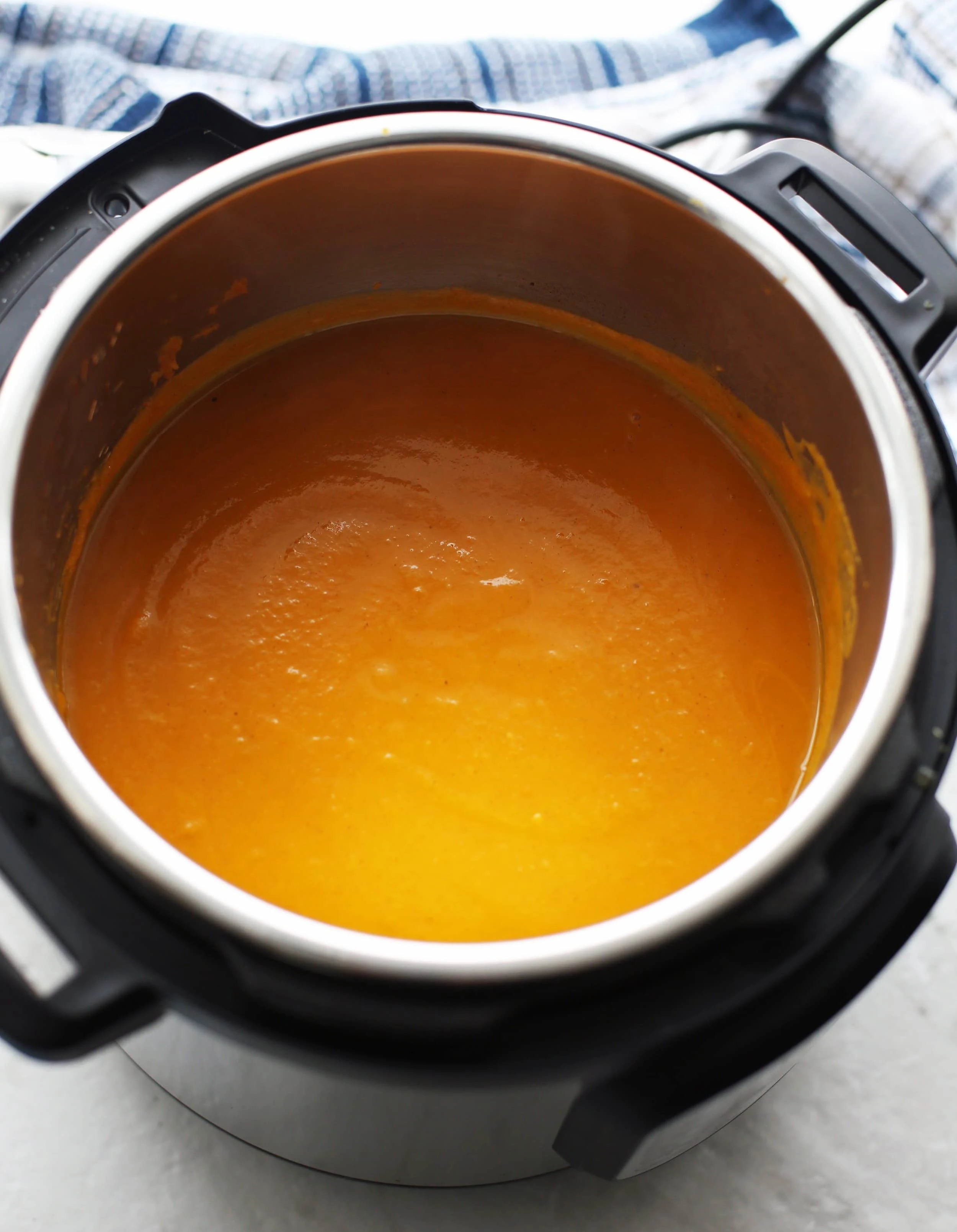 A vibrant orange pureed butternut squash apple ginger soup in the Instant Pot.