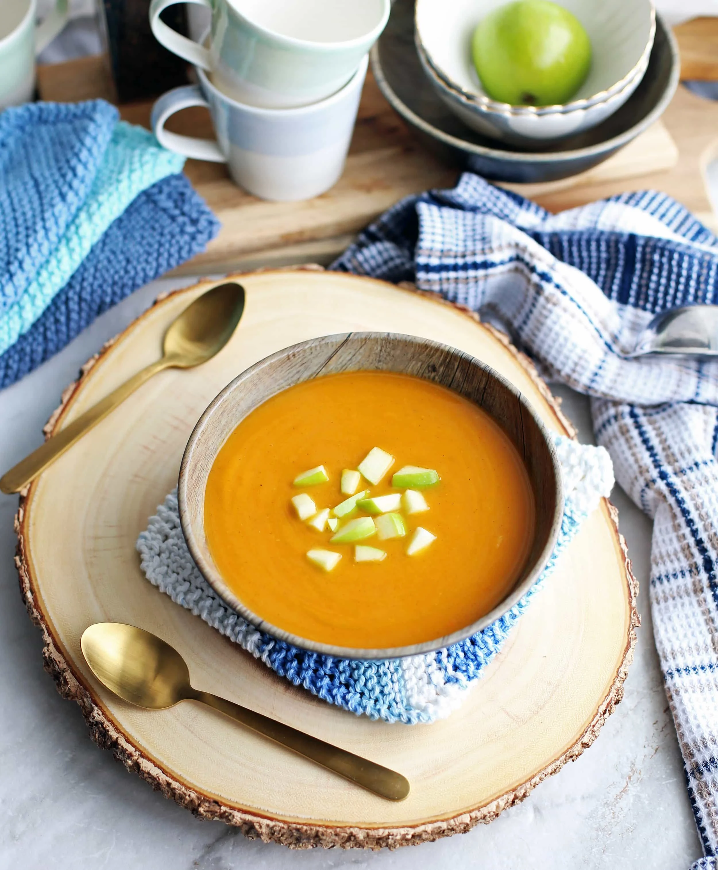 An overhead view of a bowl of butternut squash apple ginger soup with diced green apples on top that was made in the Instant Pot.