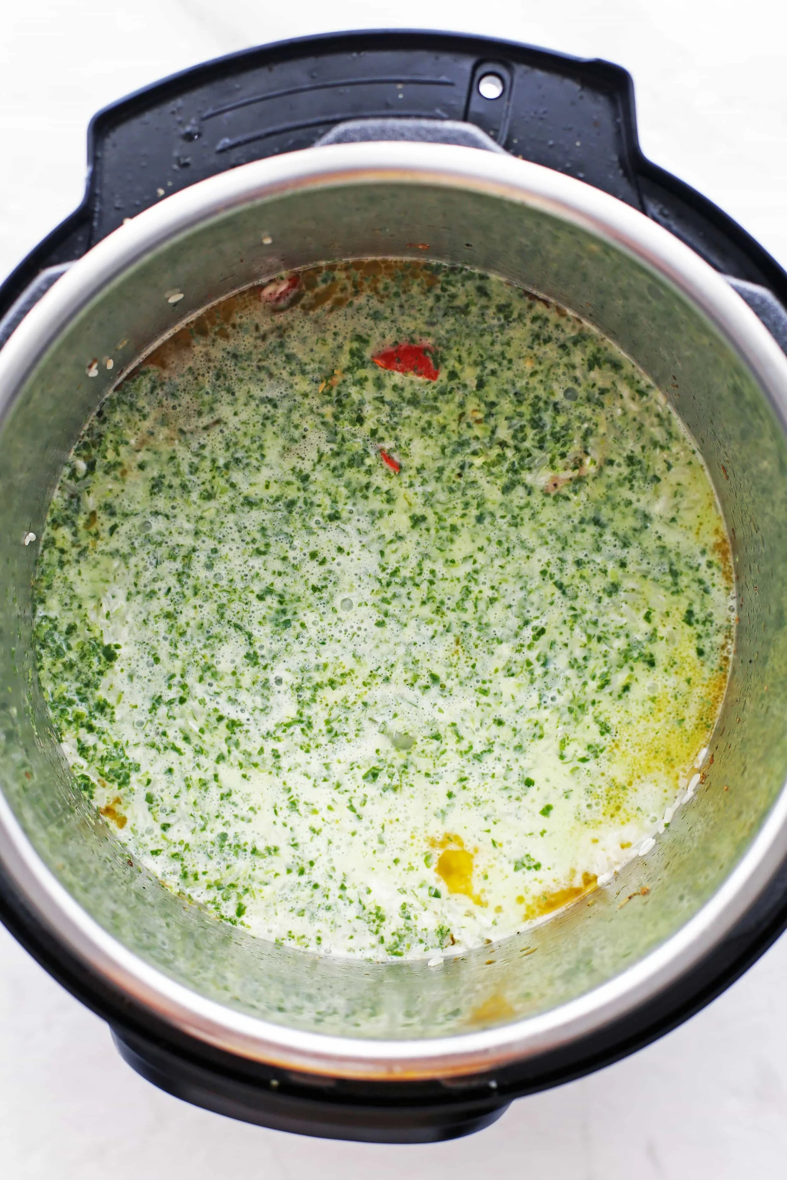 Browned chicken thighs, sautéed chopped bell pepper and onions that's topped with cilantro lime coconut sauce in an Instant Pot.