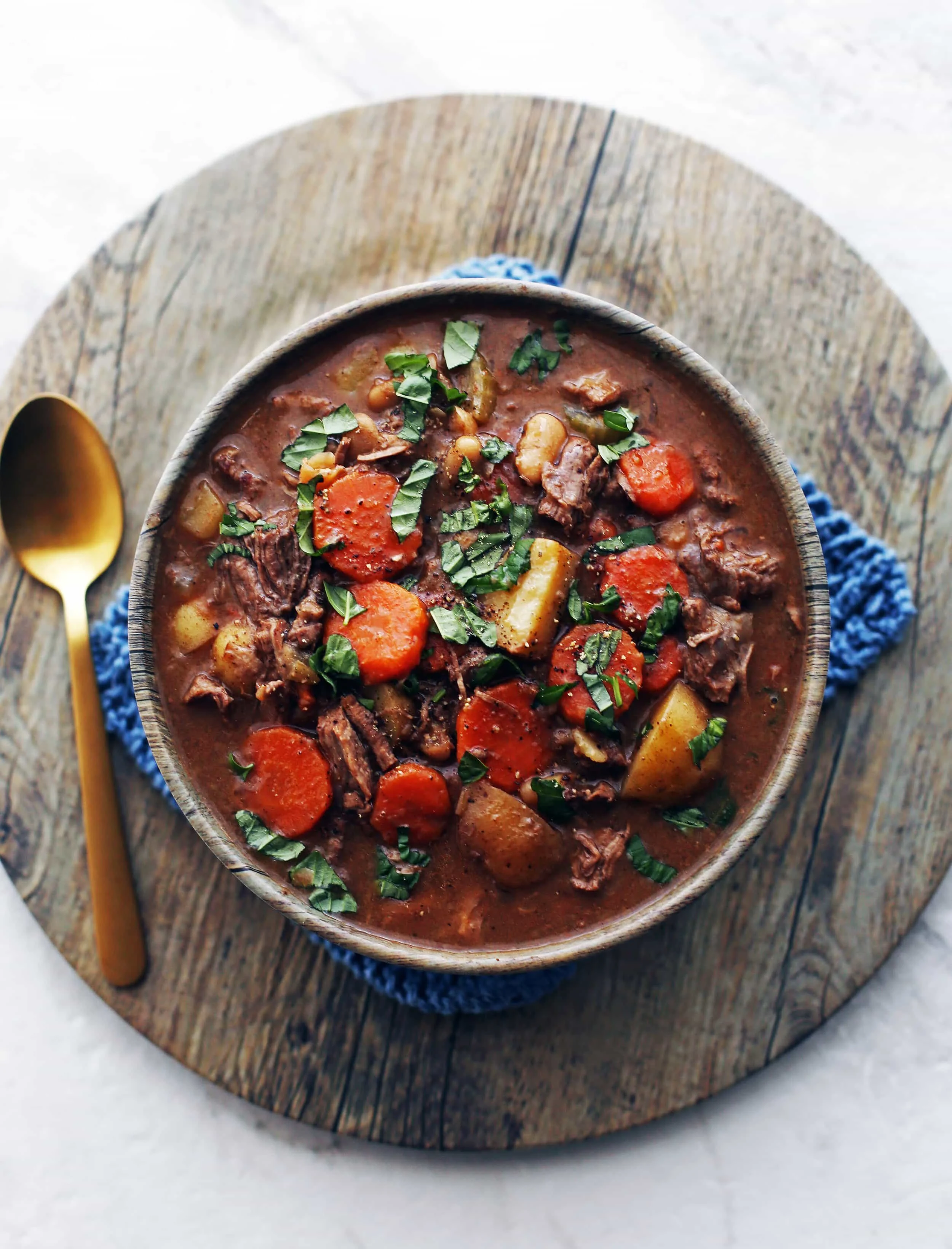 An overhead view of Instant Pot Chinese Five Spice Beef and Vegetable Stew with sliced basil on top.