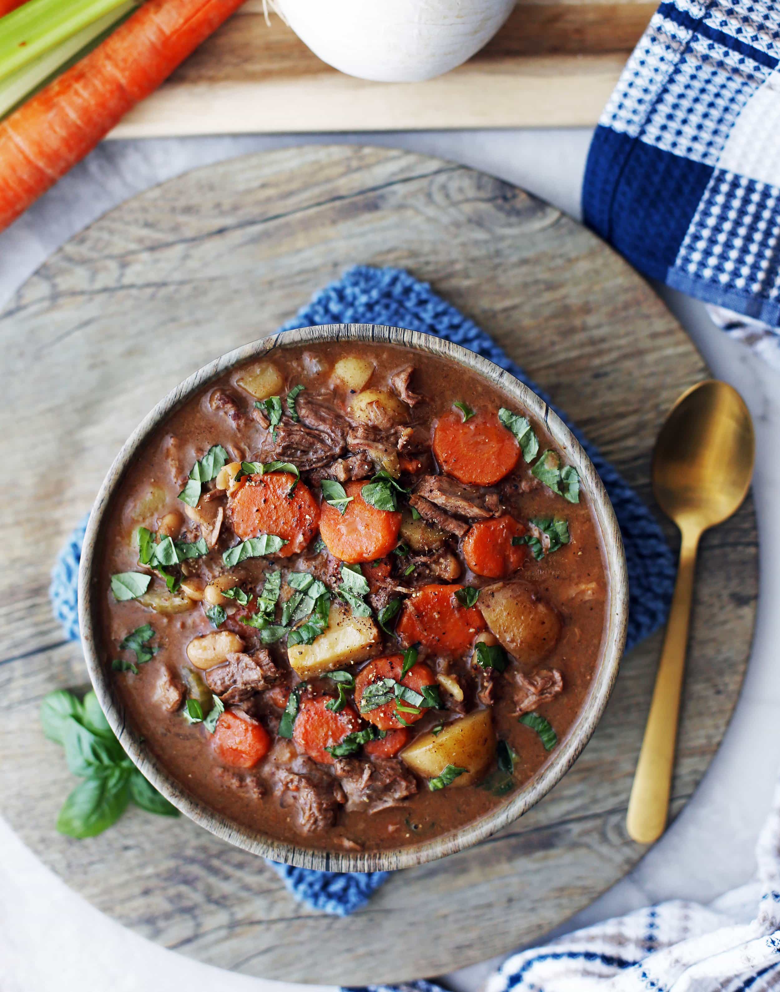 A filled bowl of Chinese Five Spice Beef and Vegetable Stew with sliced basil on top.