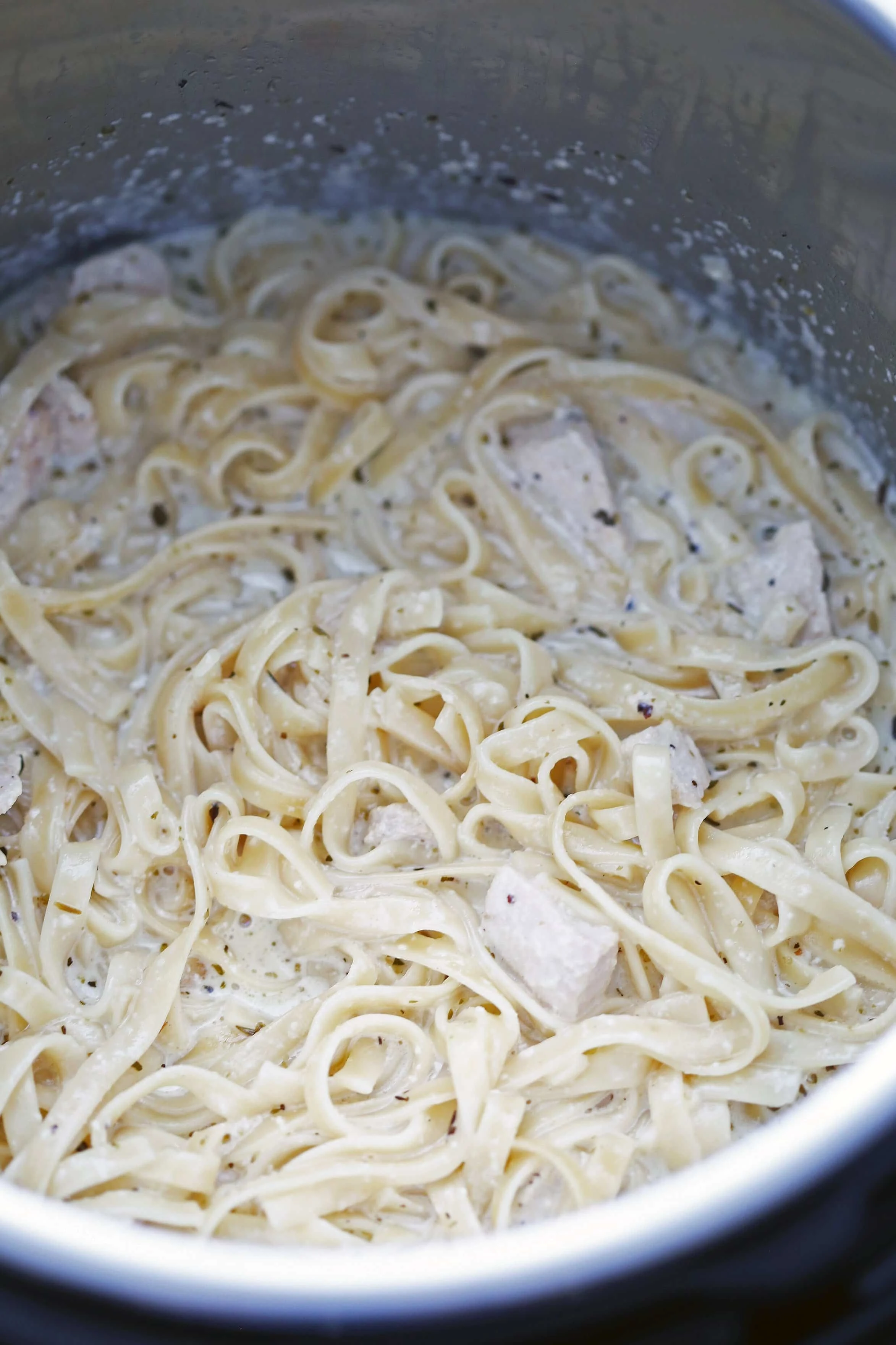 Cooked fettuccine pasta tossed in a cream sauce and diced chicken in the Instant Pot.
