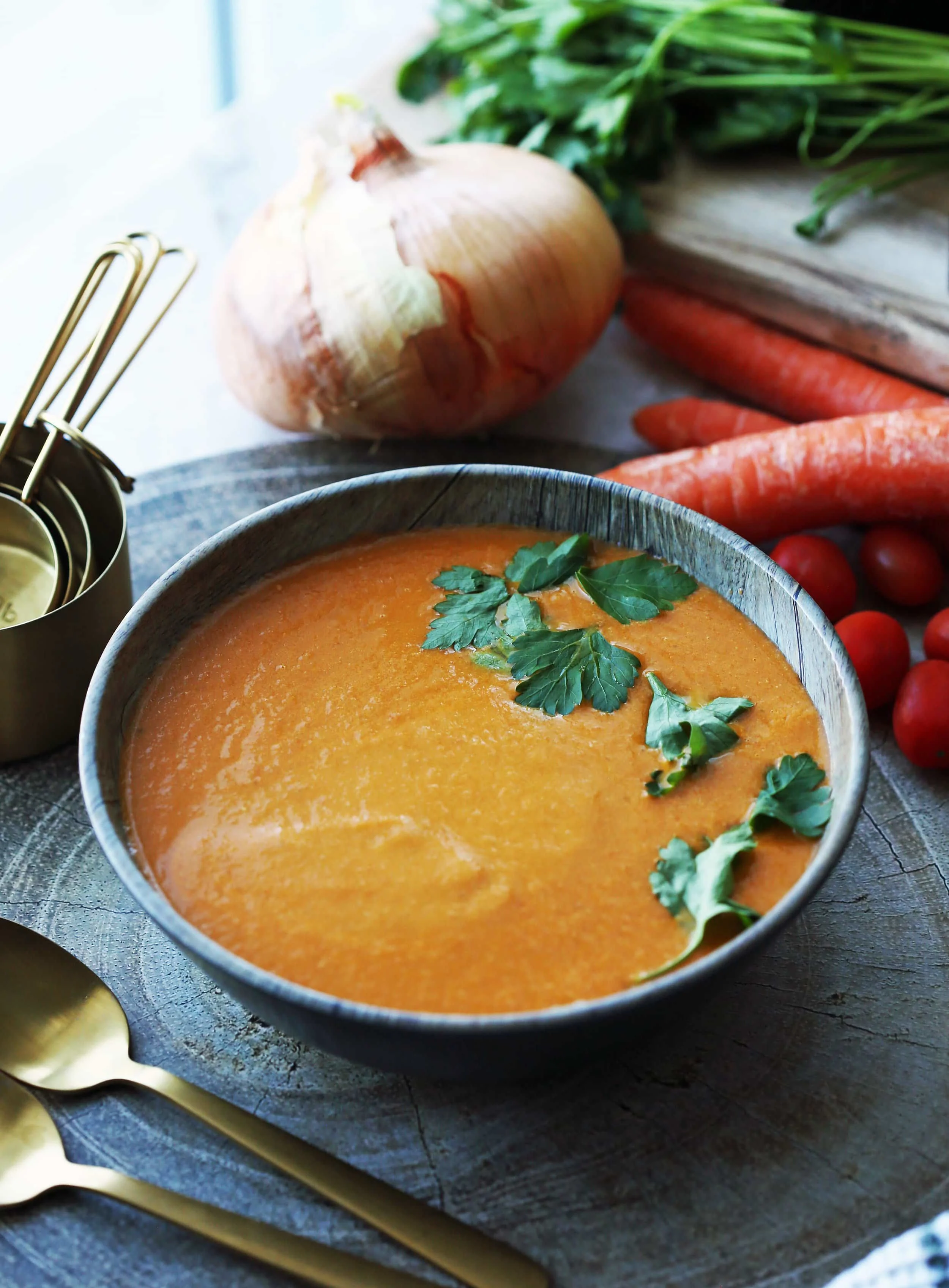 A wooden bowl containing Instant Pot. homemade tomato soup with parsley garnish on top.