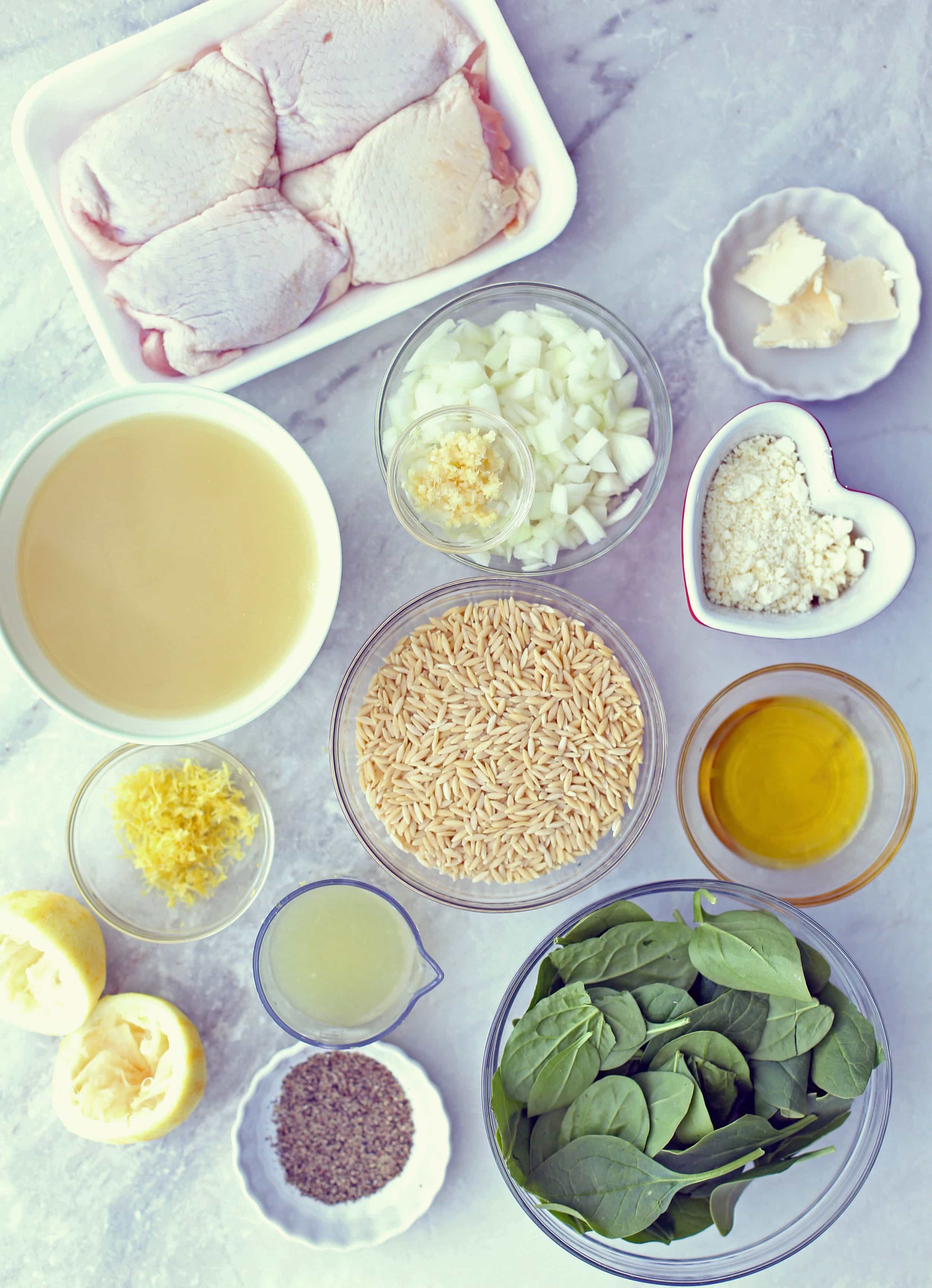 Pack of chicken thighs, bowls of orzo, spinach, feta, onions, garlic, lemon juice, zest, black pepper, and chicken broth.