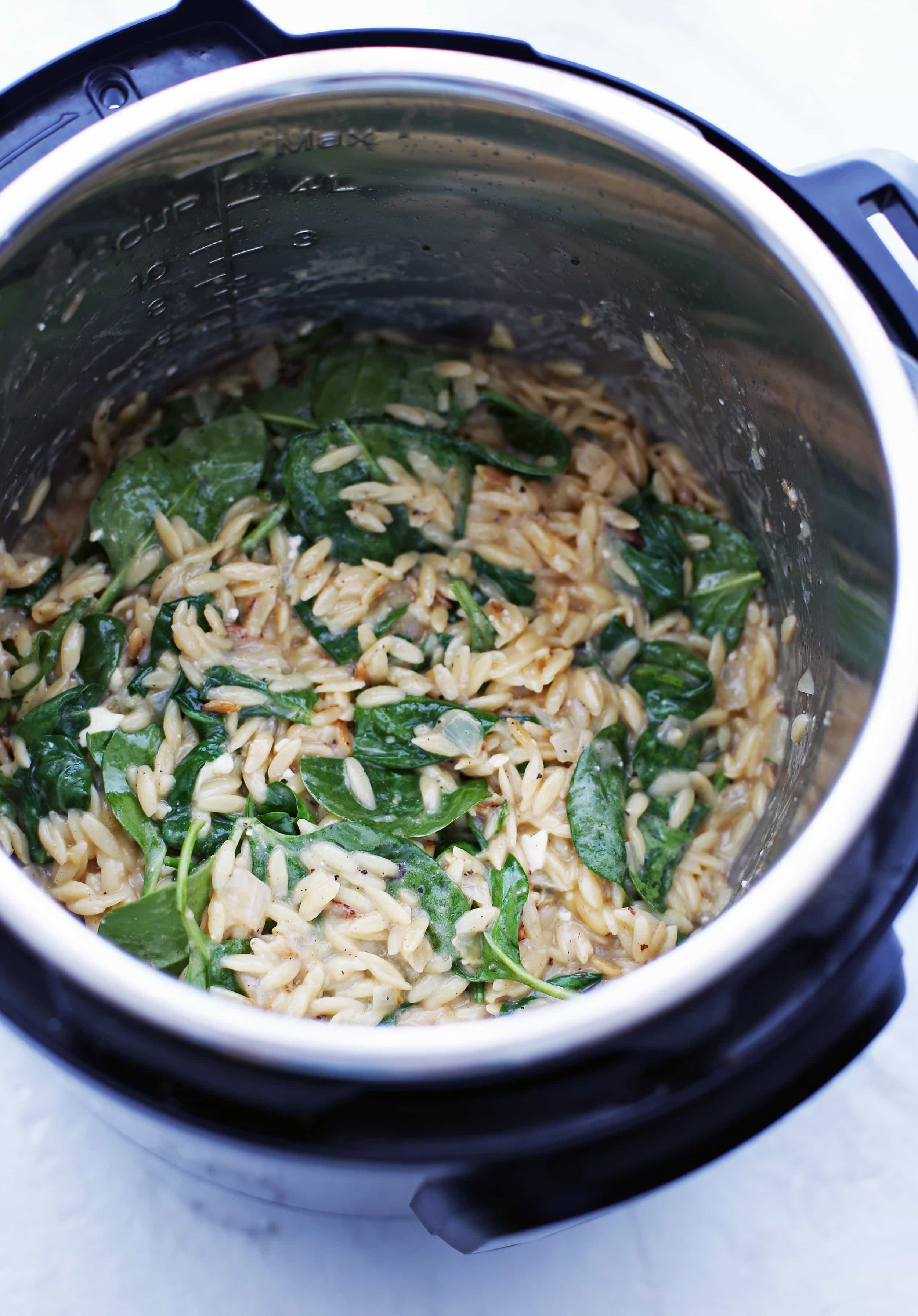 Cooked lemon pepper orzo with feta and spinach in an Instant Pot.