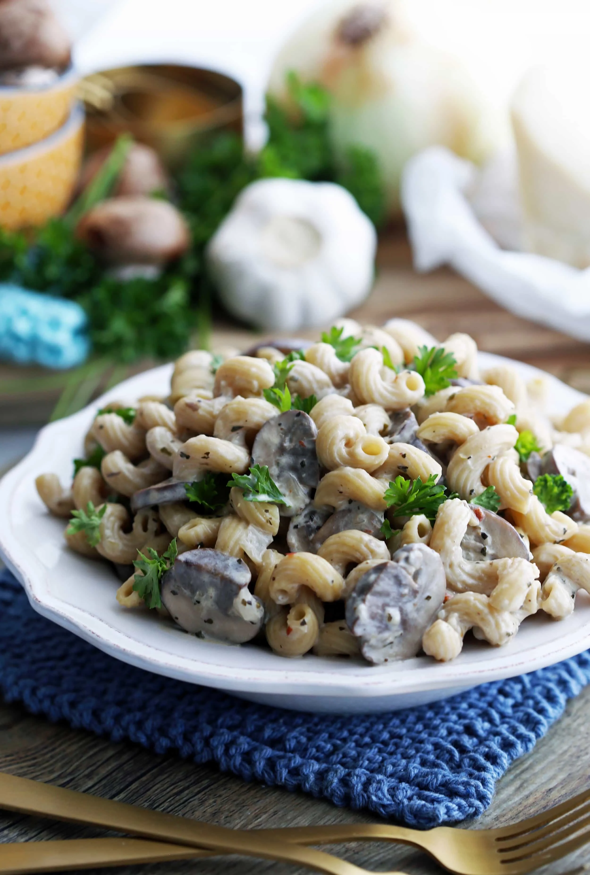 Close-up side view of mushroom pasta with creamy parmesan sauce in a white pasta bowl.