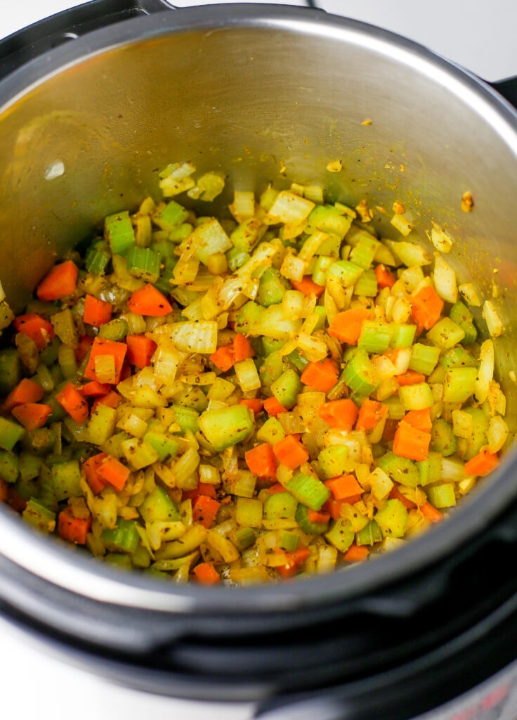 Sautéed diced carrots, onions, and celery with minced garlic and spices in the Instant Pot.