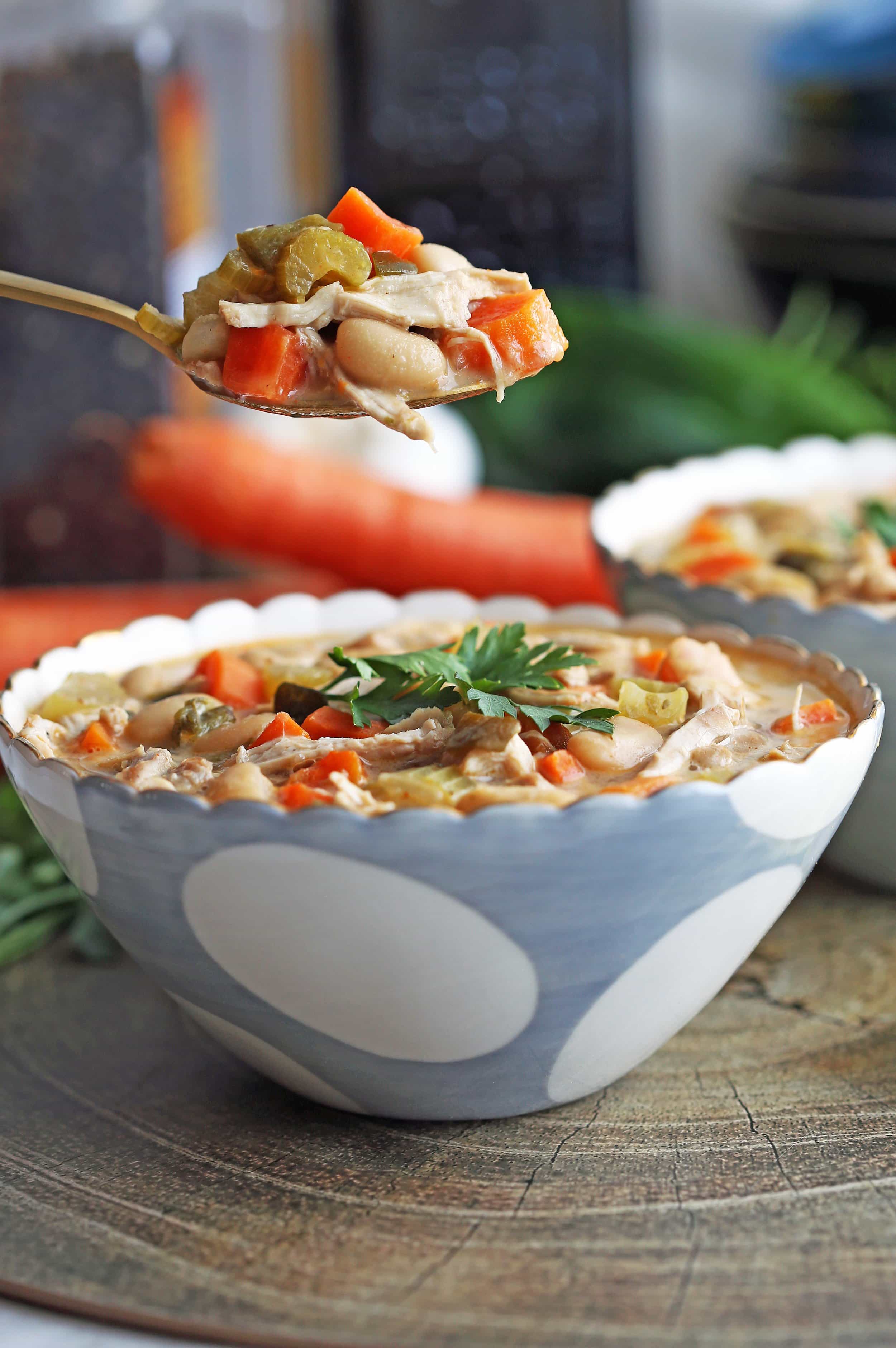 A spoonful of Instant Pot White Bean Chicken Chili held over a bowl full of more chili.