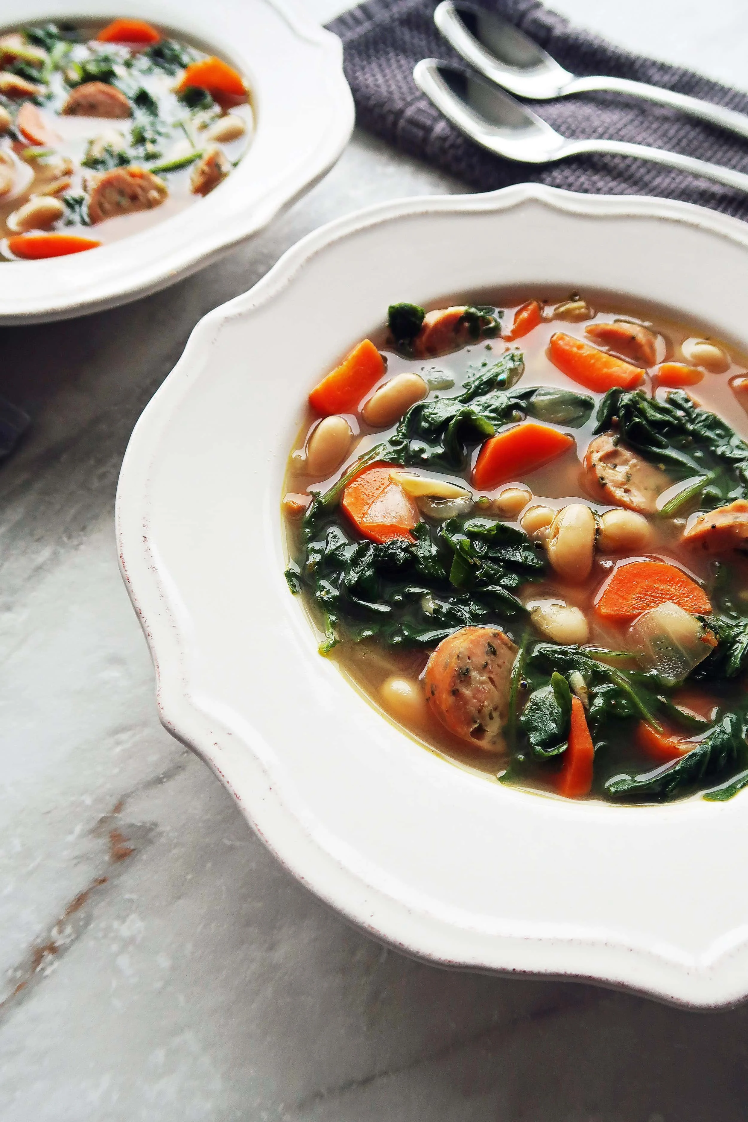 A close up view of Kale, White Bean, and Sausage Soup in a bowl.