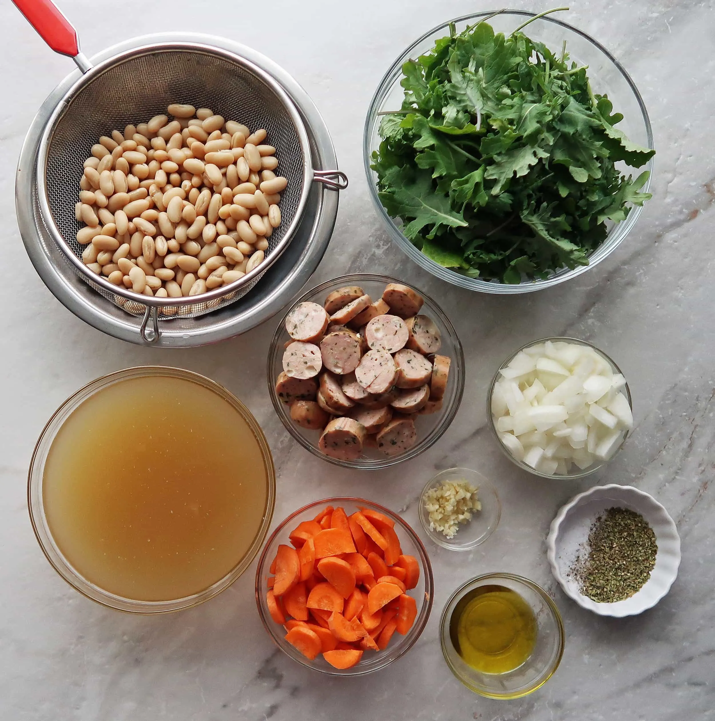 Carrots, onions, sausages slices, white beans, kale, and broth.