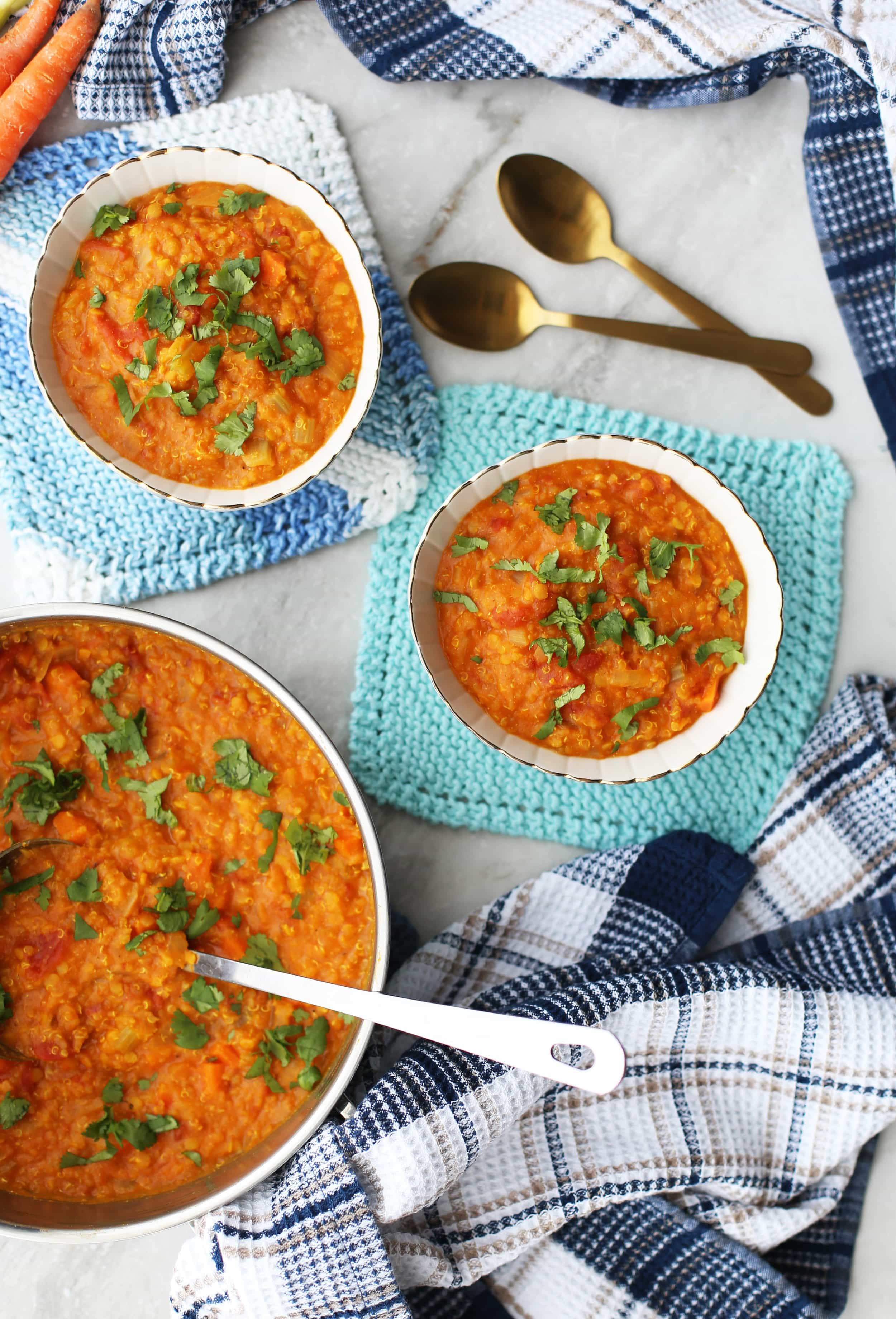 Overhead view of Curried Red Lentil and Quinoa Vegetable Soup in two small bowls and in a large pot.