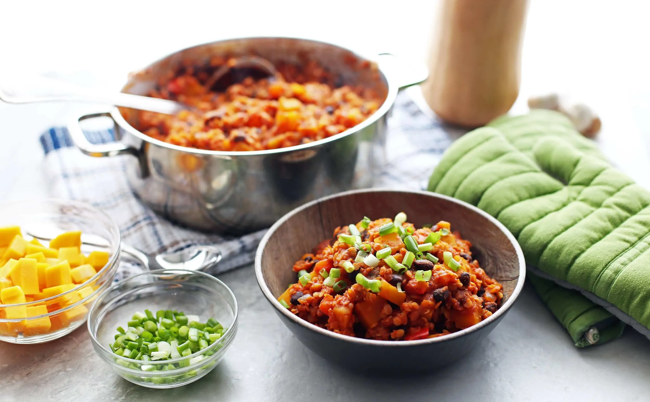 Lentil and butternut squash chili in a bowl; chili in a large pot.