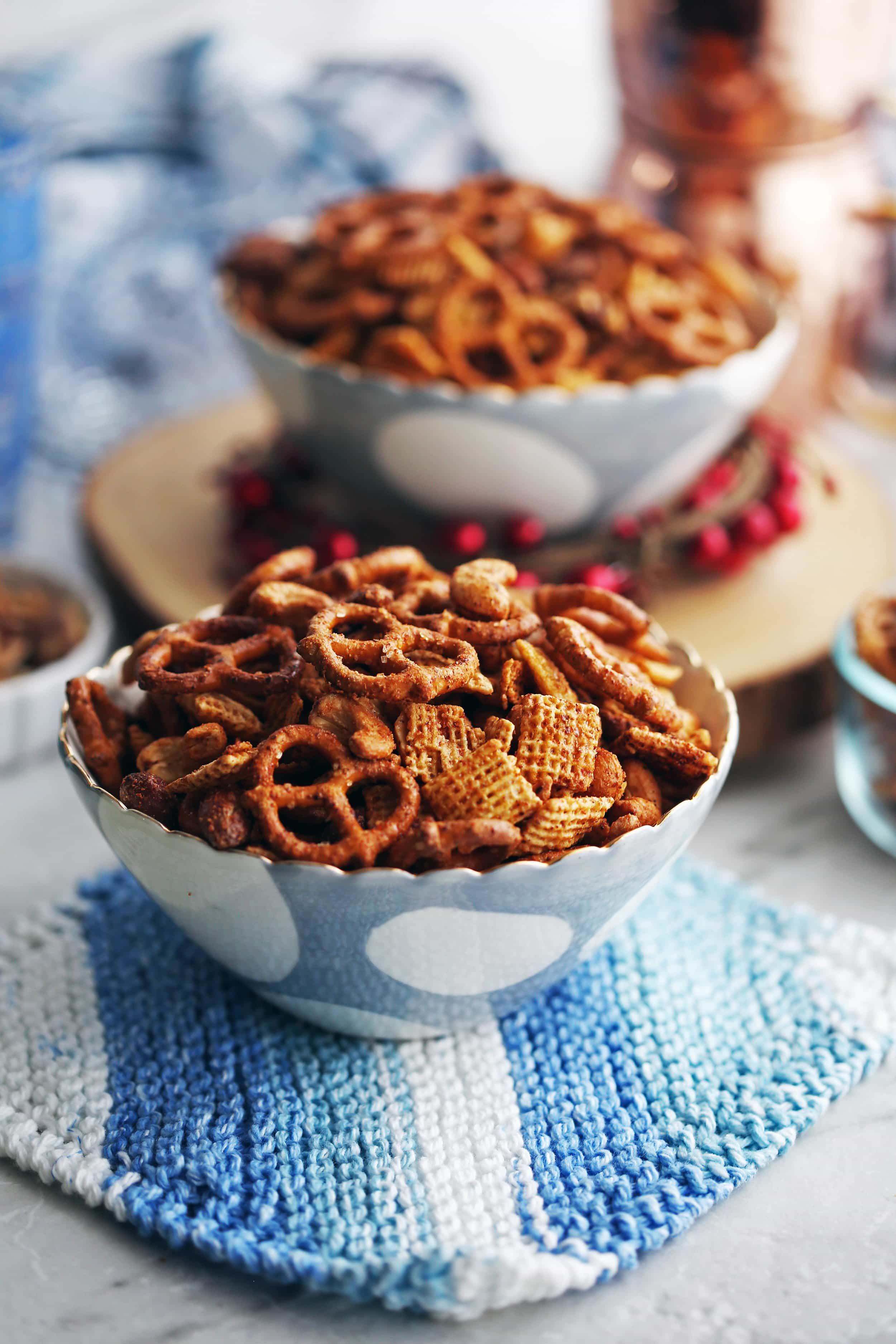 Side view of two blue bowls of filled Maple Chili Nuts and Chex Snack Mix.