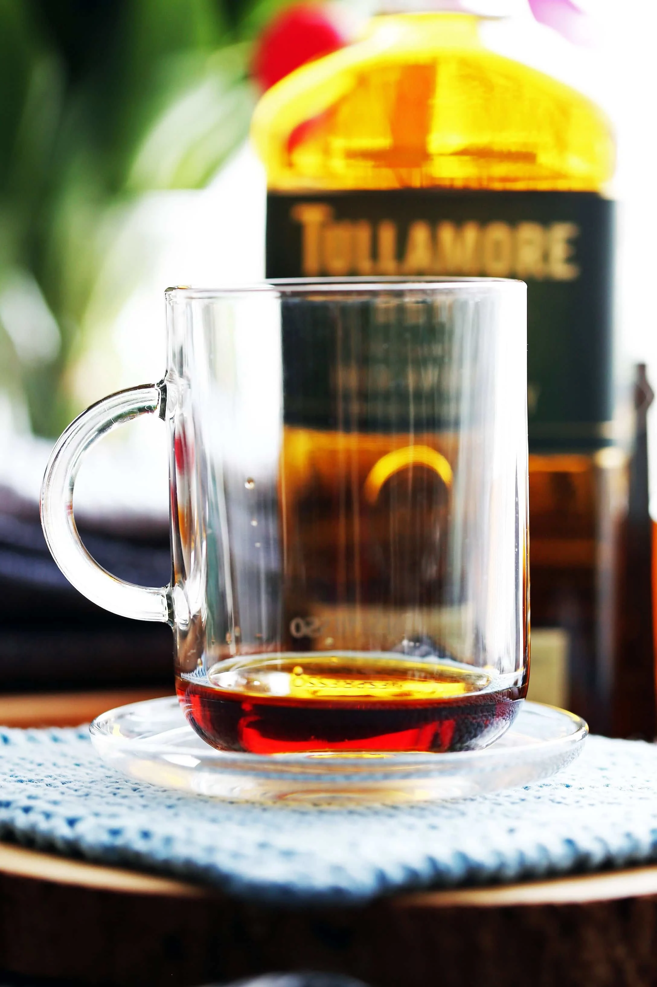 A side view of a glass mug filled with two tablespoons of maple syrup.