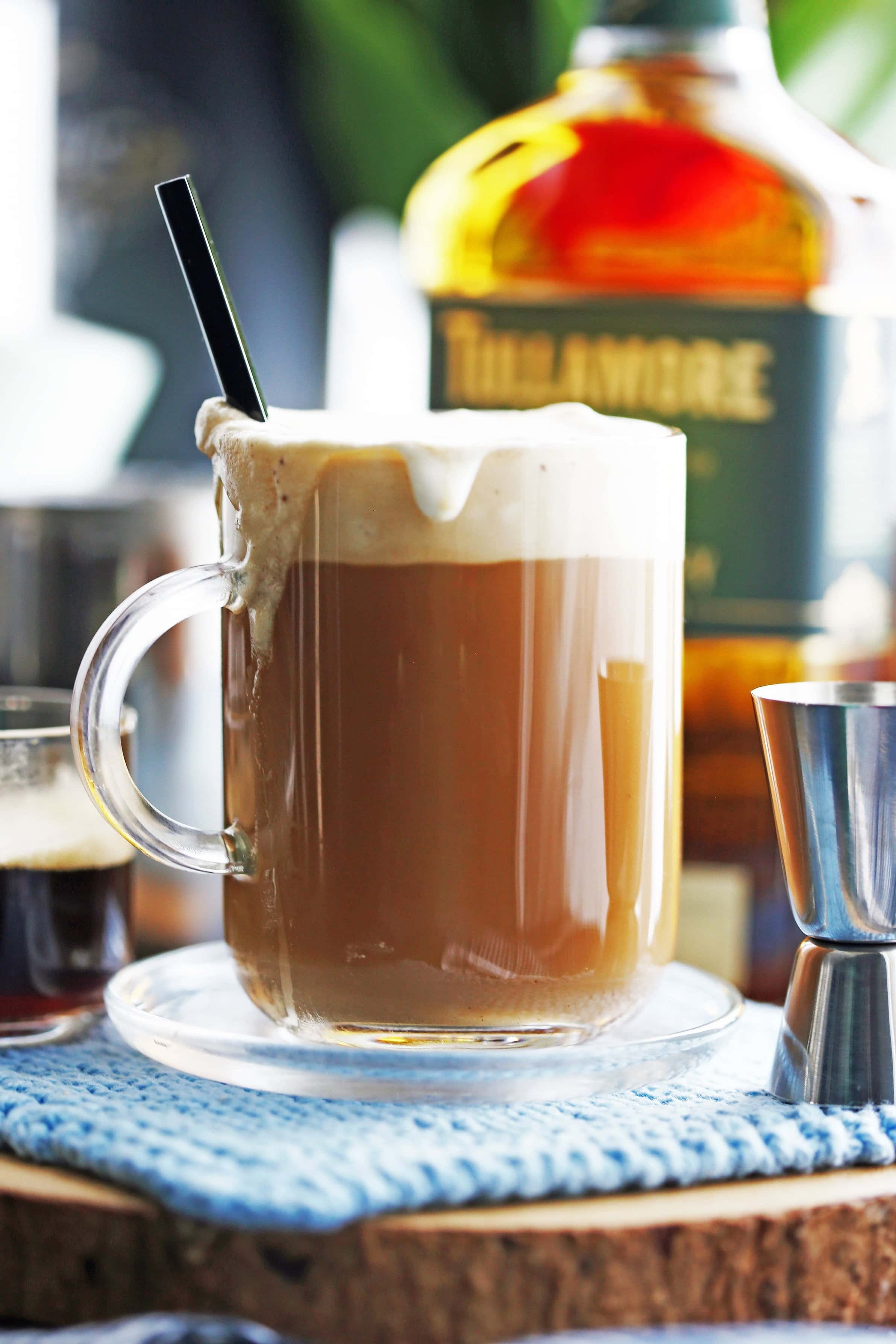 A stirred cup of Maple Irish Coffee in a glass mug with a spoon in it.