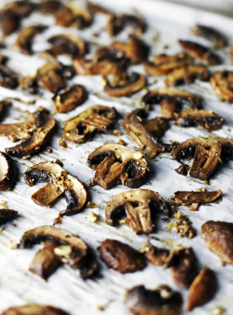 Roasted lemon garlic mushrooms on a parchment paper lined baking sheet.