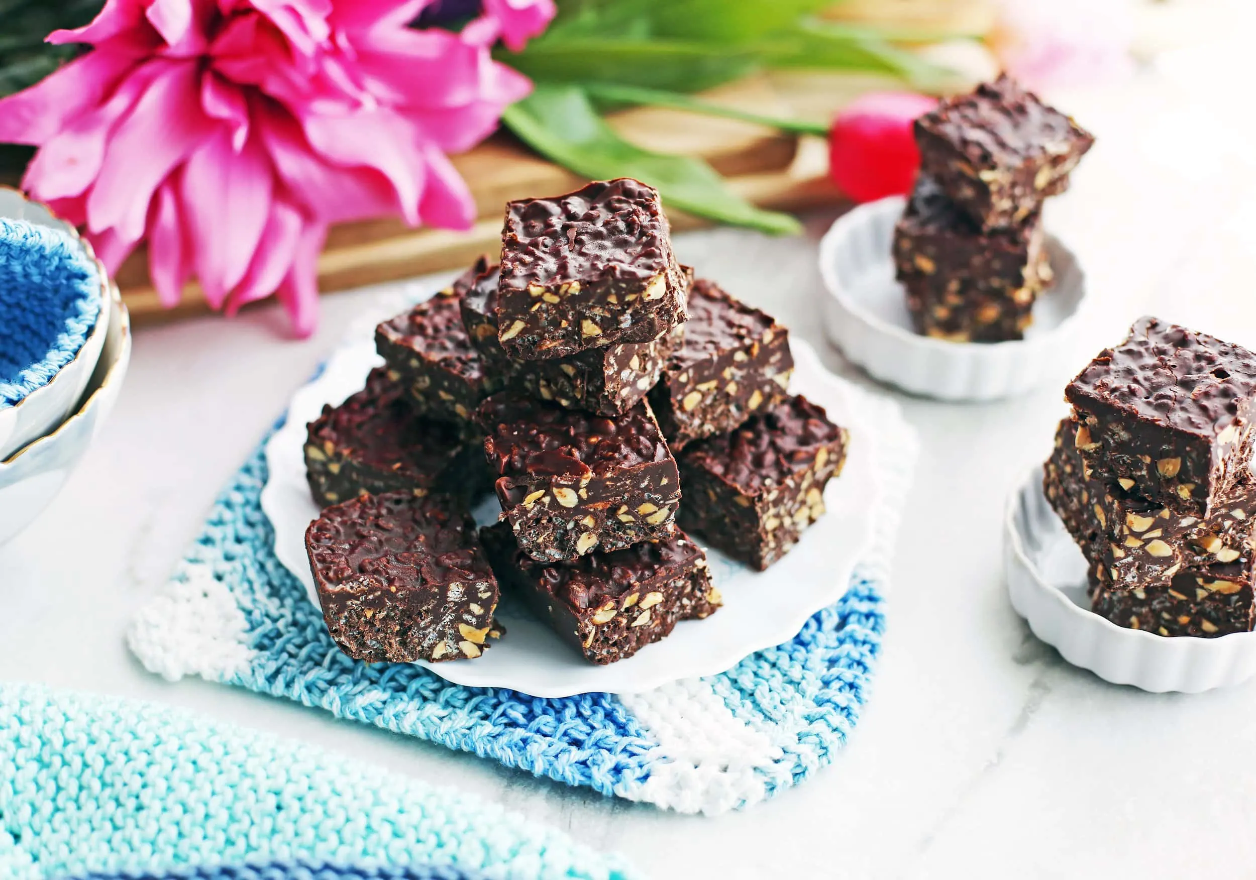 No-bake Peanut Butter Chocolate Crunch Bars arranged casually on three white plates.