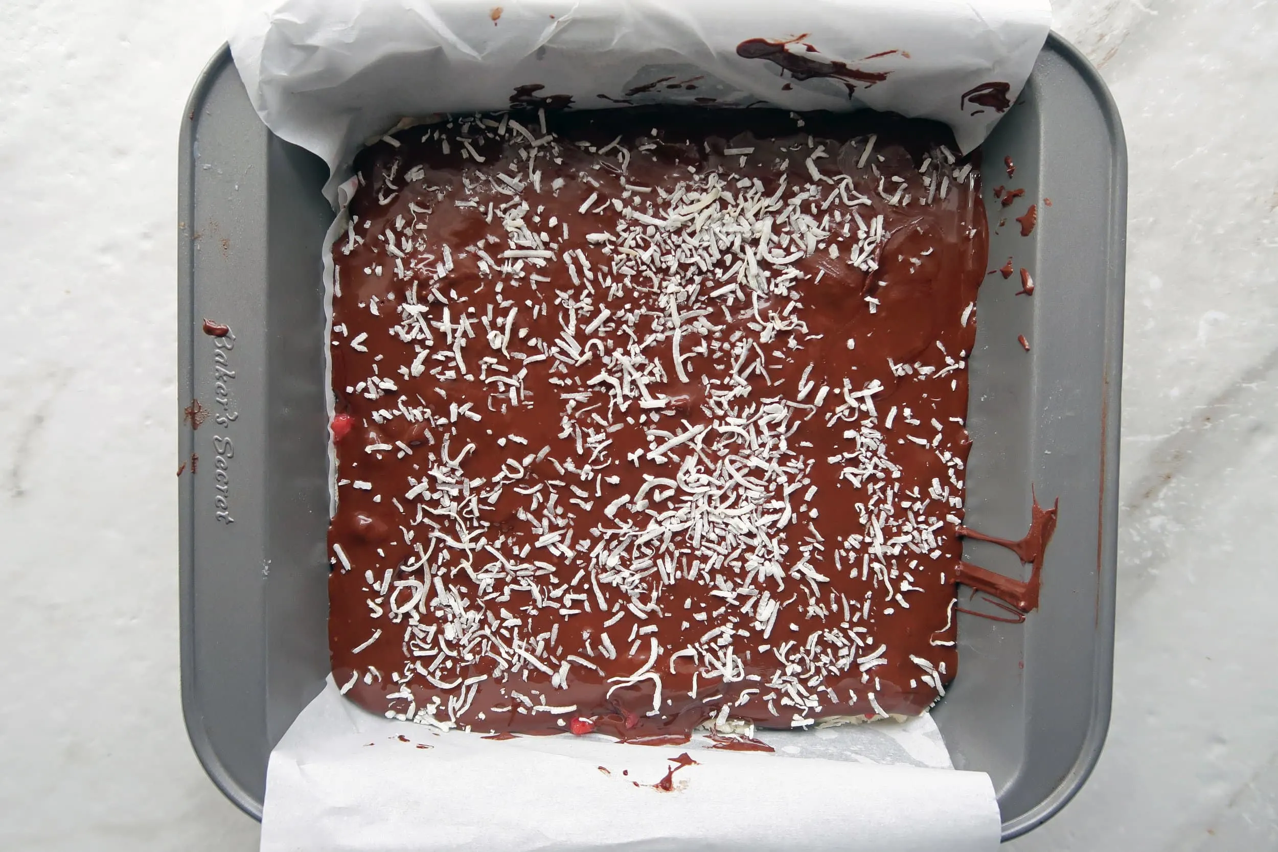 No-bake Chocolate Strawberry Coconut Bars in a square baking pan.
