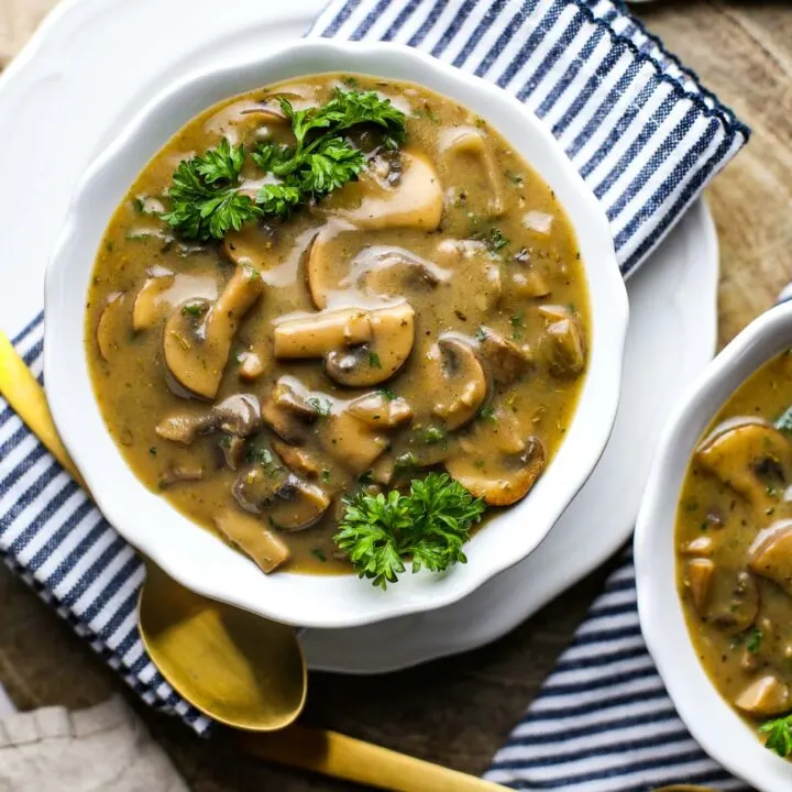 Overhead view of creamy vegan mushroom soup in a white bowl.