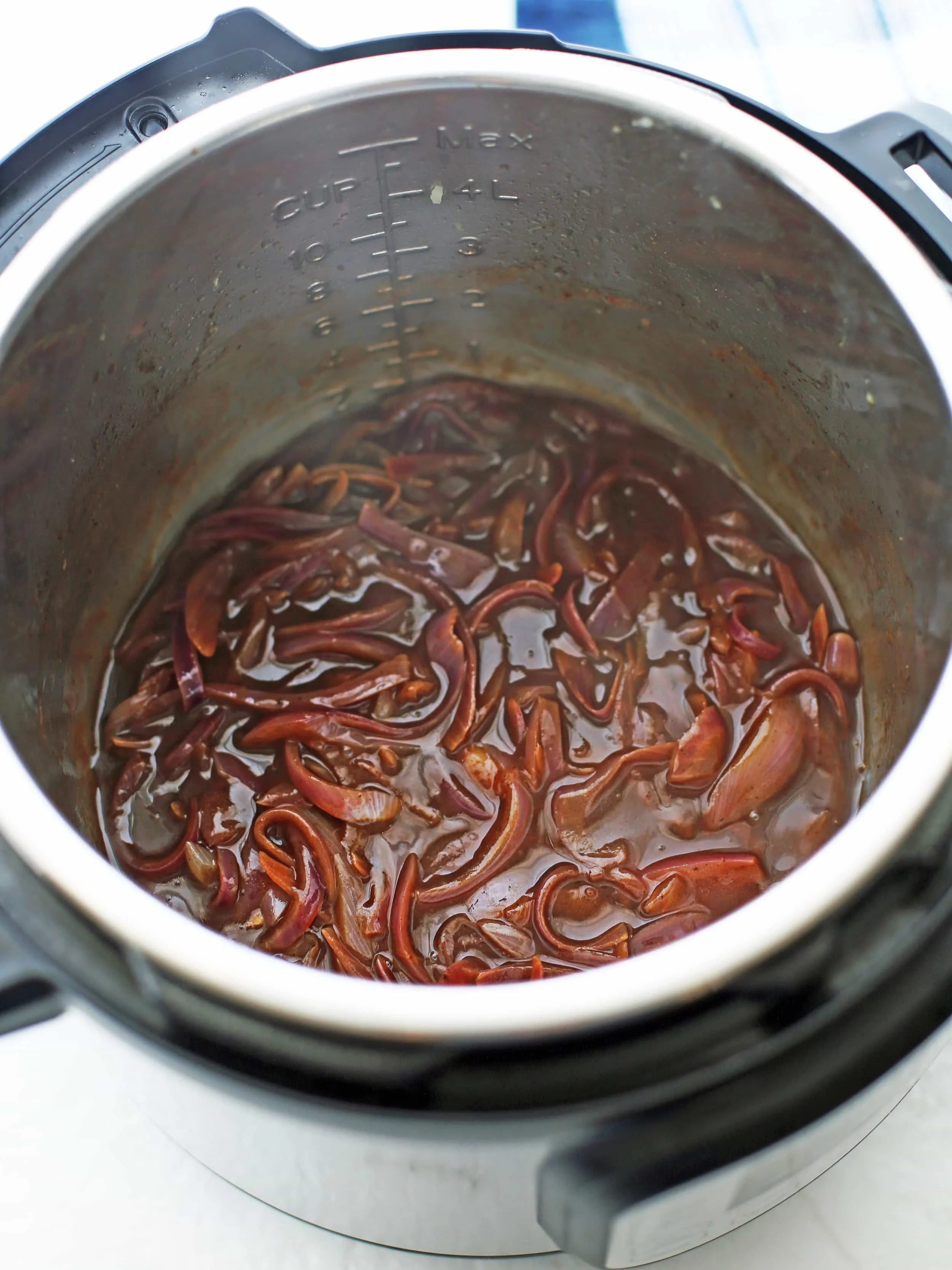 A thick gravy made from beef broth, sliced red onions, and balsamic vinegar in the Instant Pot.