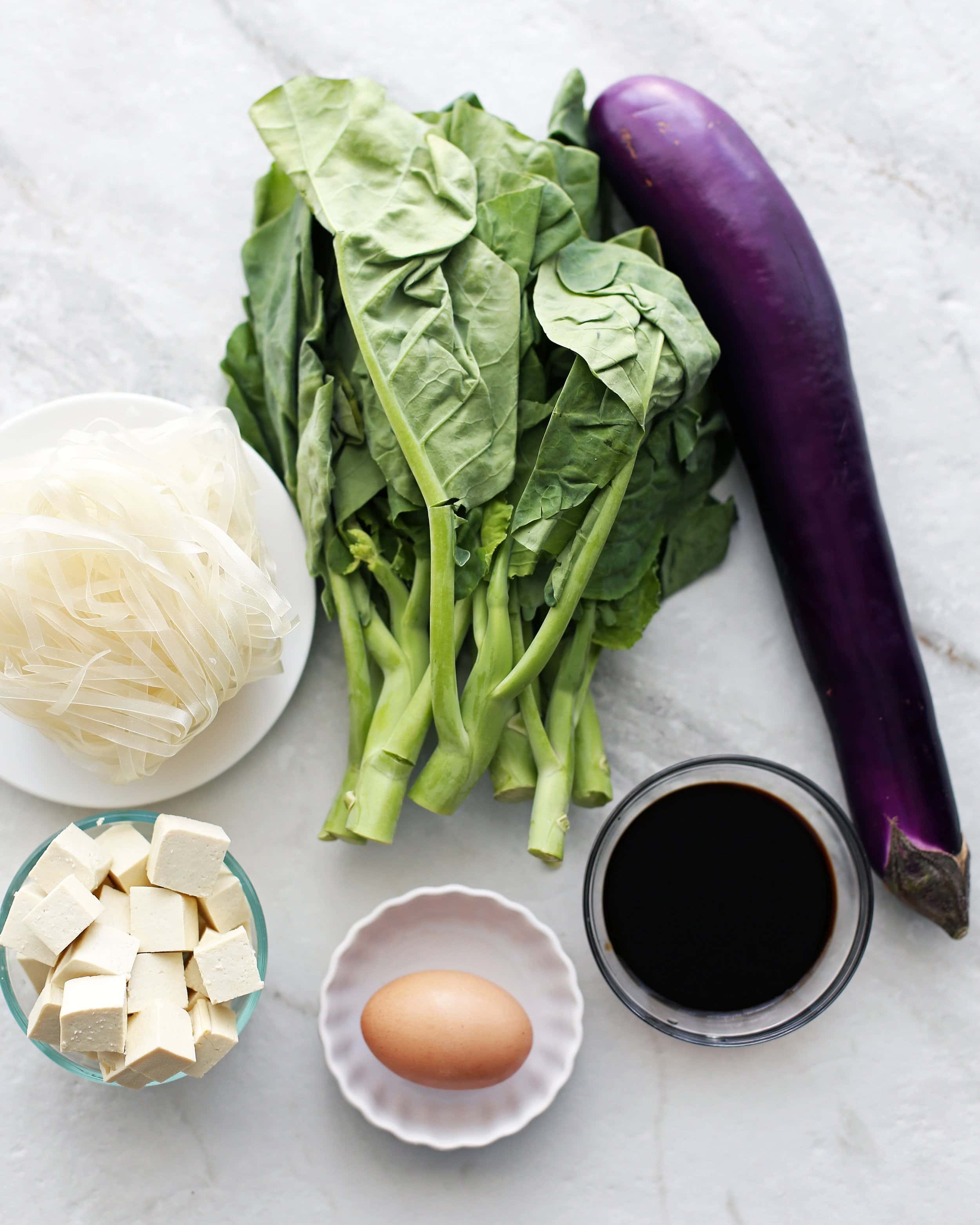 eggplant, tofu, gai lan, and garlic on the cutting board, ready for the wok