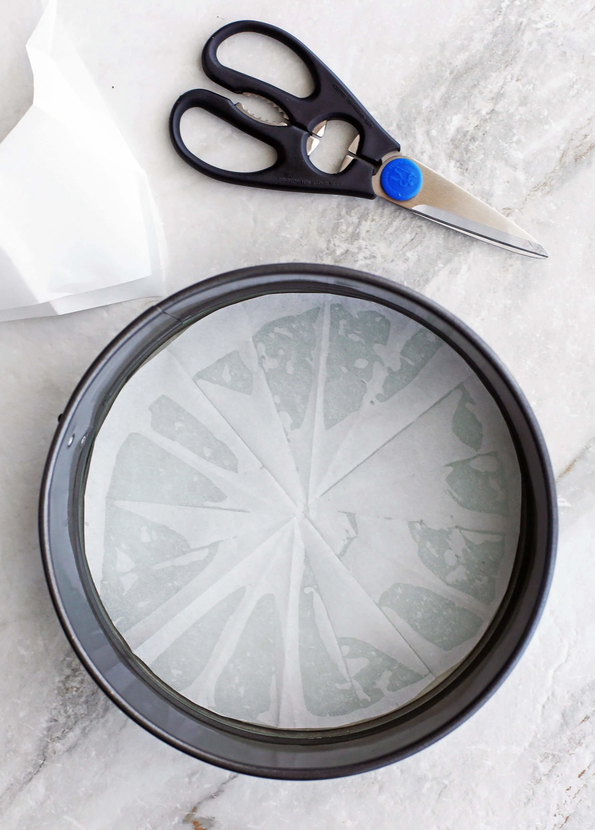 A metal 9-inch round springform pan that's been greased and lined with parchment paper.