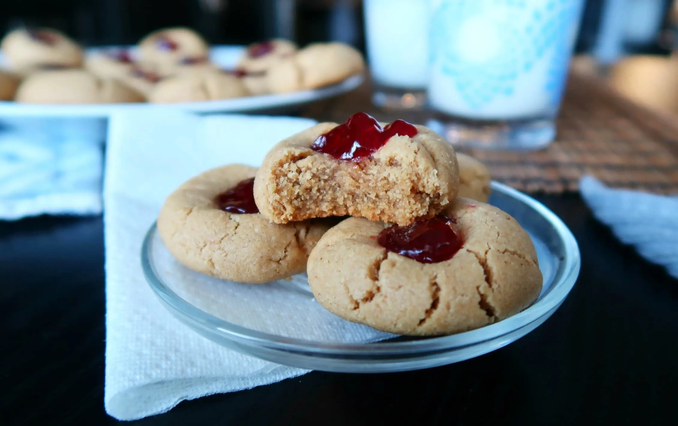 A Peanut Butter and Jelly Thumbprint Cookie with a bite missing.
