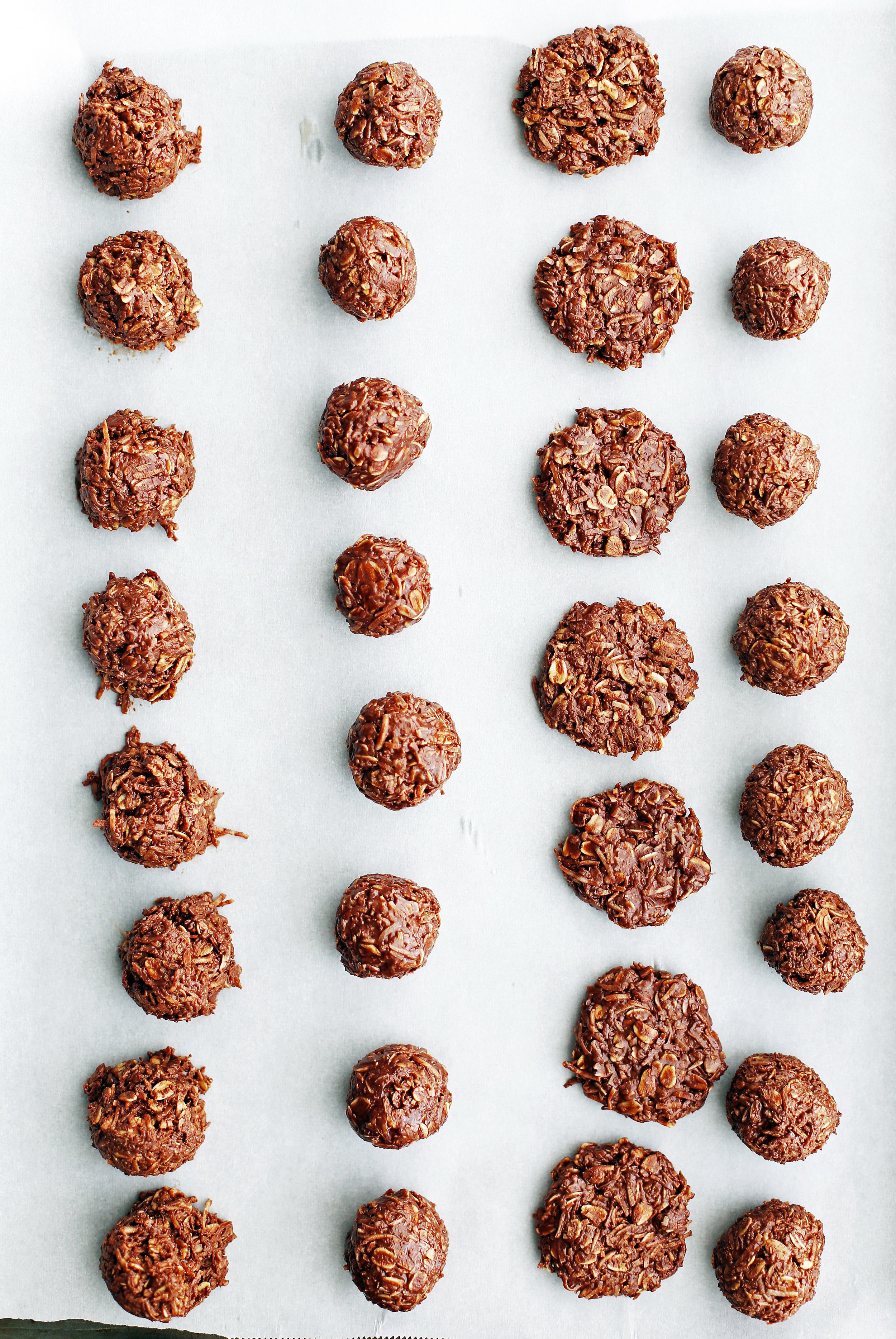 No-Bake Peanut Butter Chocolate Coconut Cookies in rows on parchment paper.