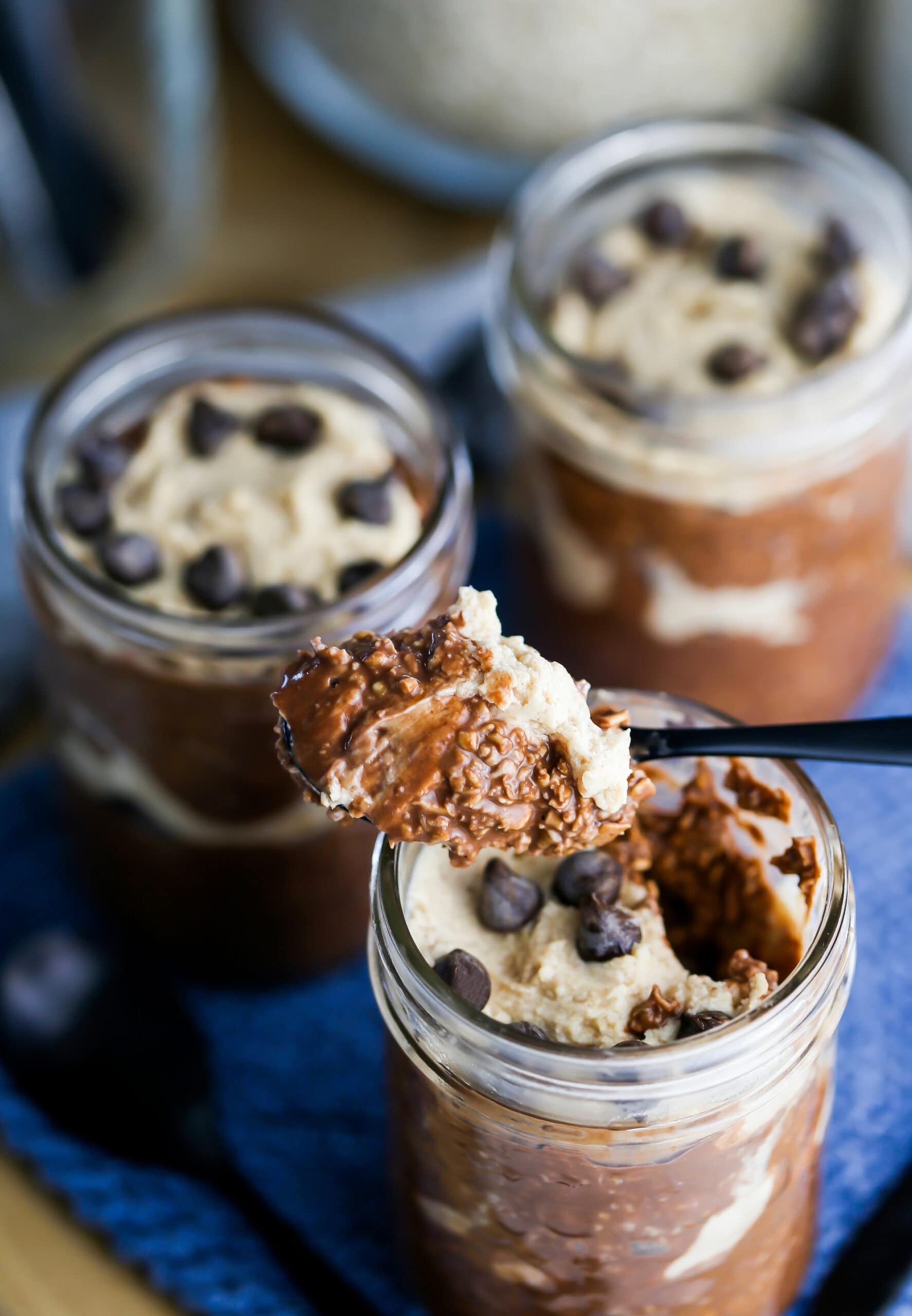 Three mason jars full of Peanut Butter Mocha Overnight Oats.