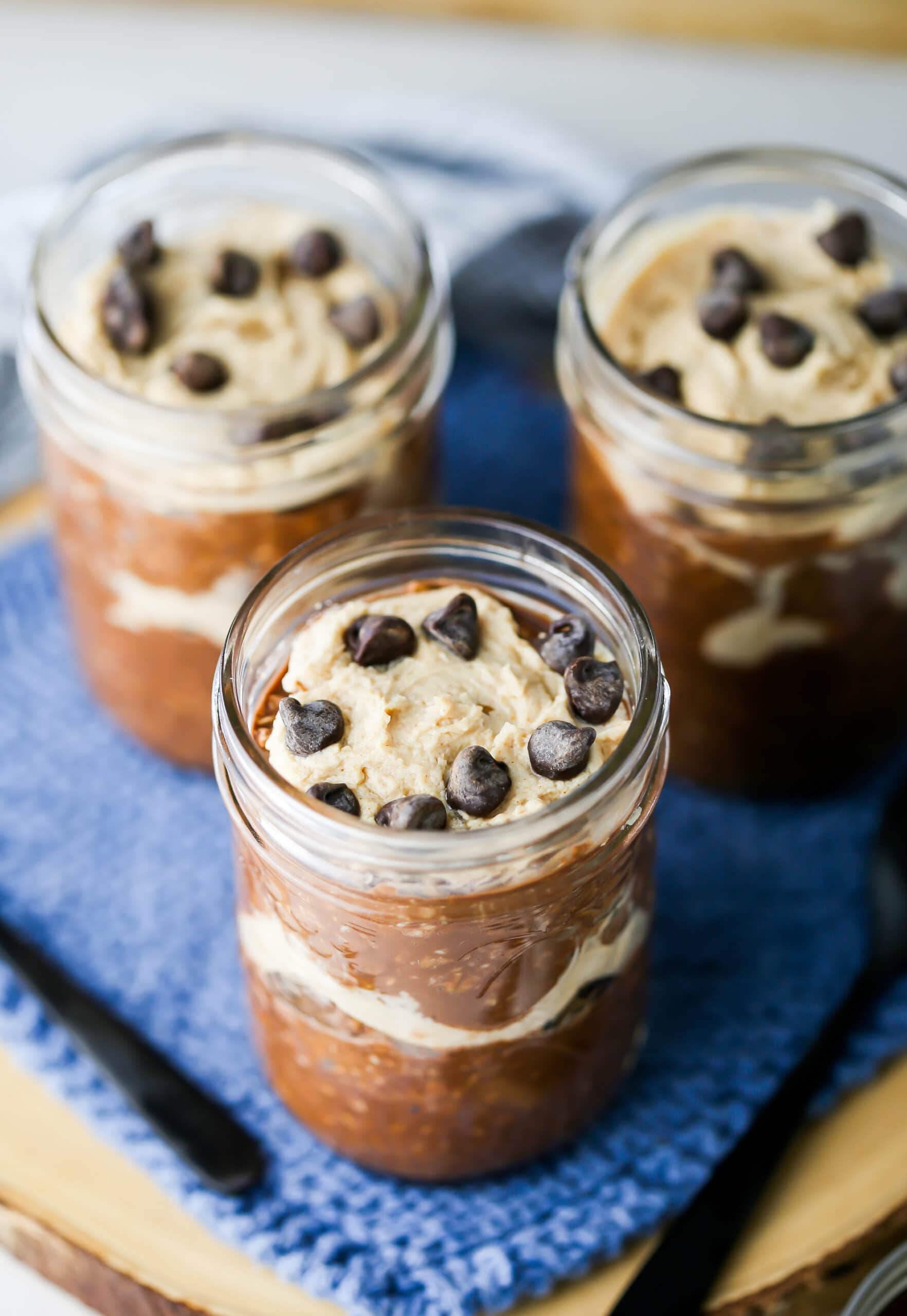 Peanut Butter Mocha Overnight Oats topped with chocolate chips in a three mason jars.