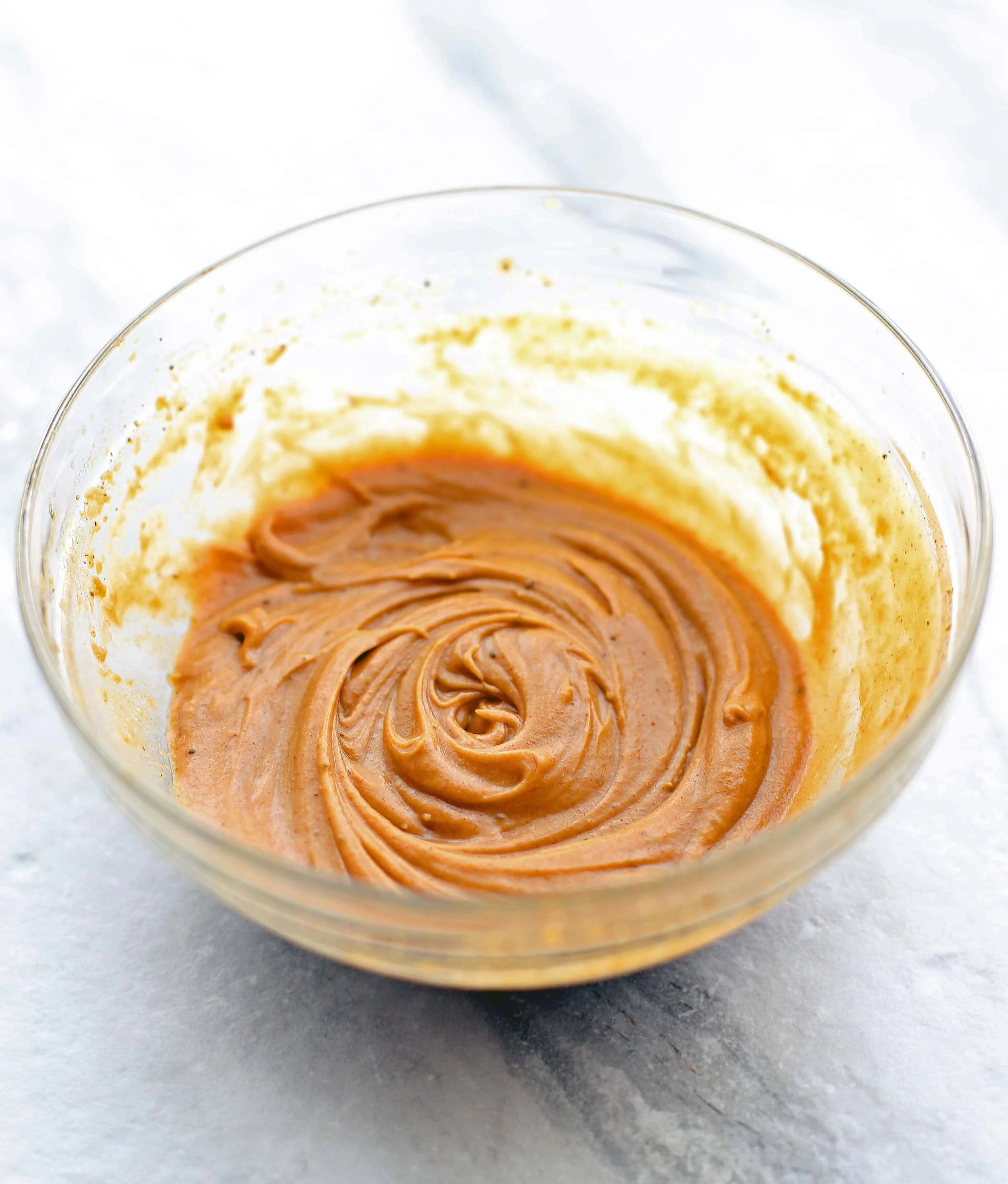 Peanut sauce in a clear glass bowl.