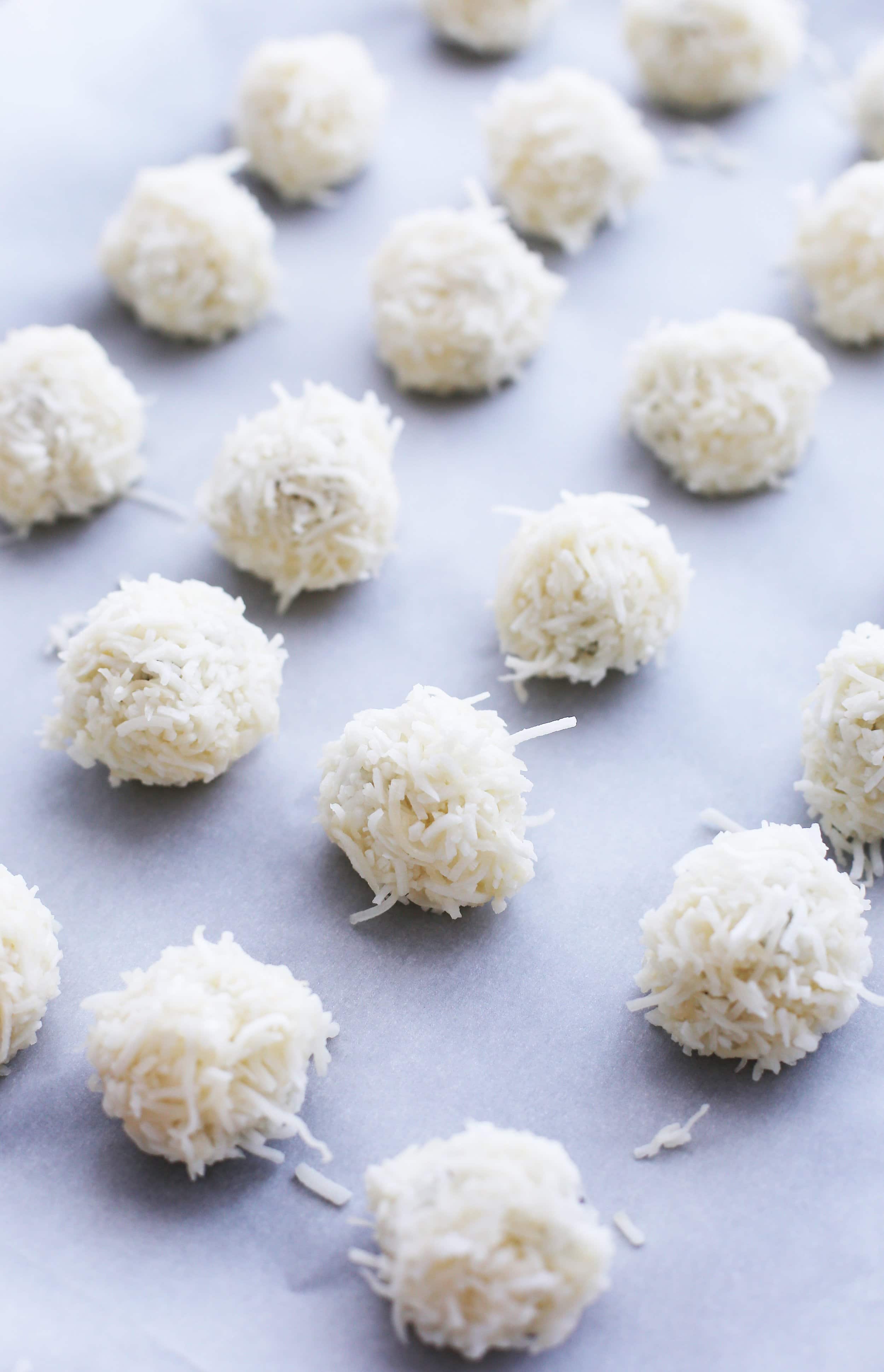 Unbaked peppermint coconut macaroons on a parchment paper-lined baking sheet.