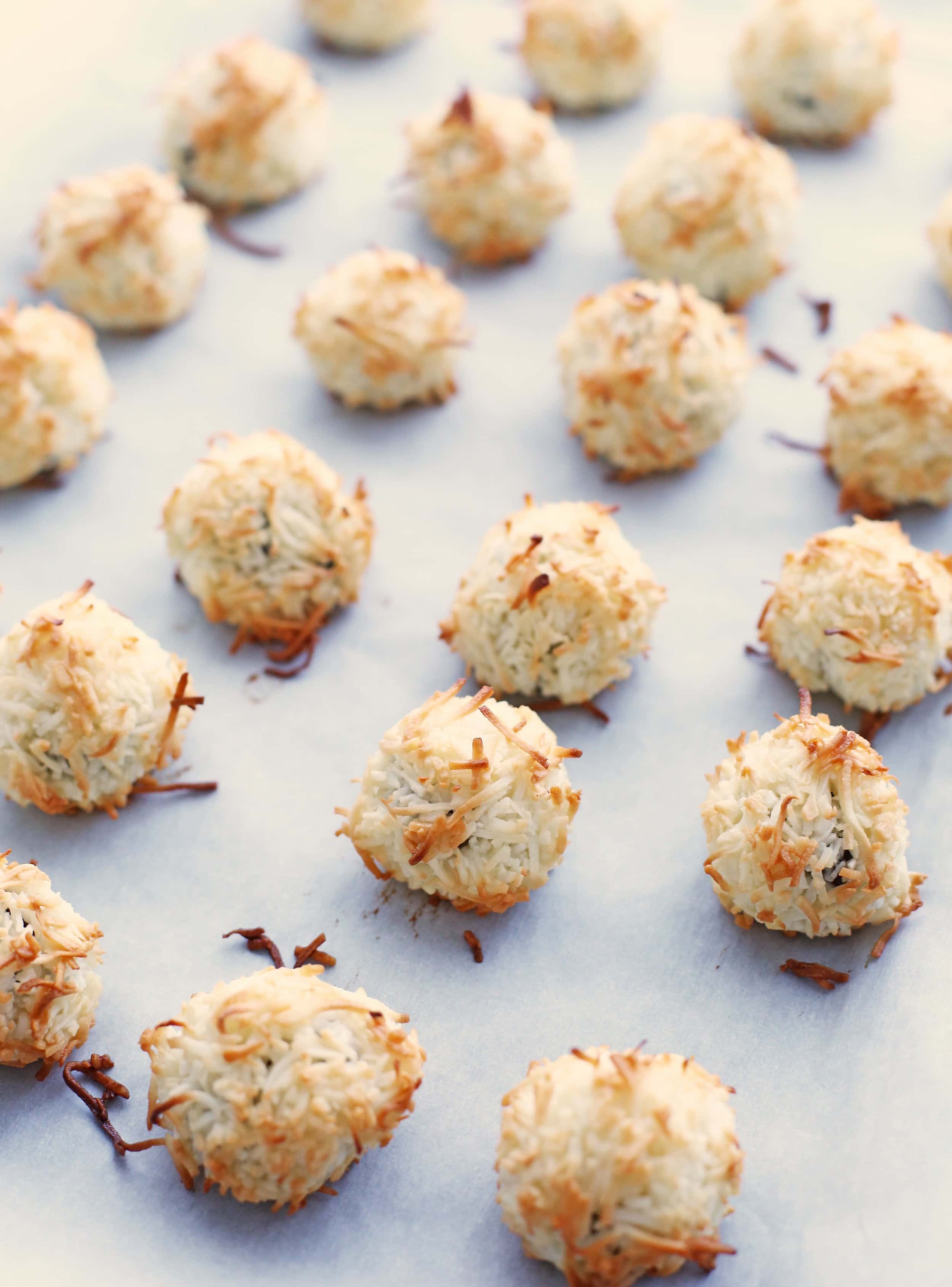 Baked peppermint coconut macaroons on a parchment paper-lined baking sheet.