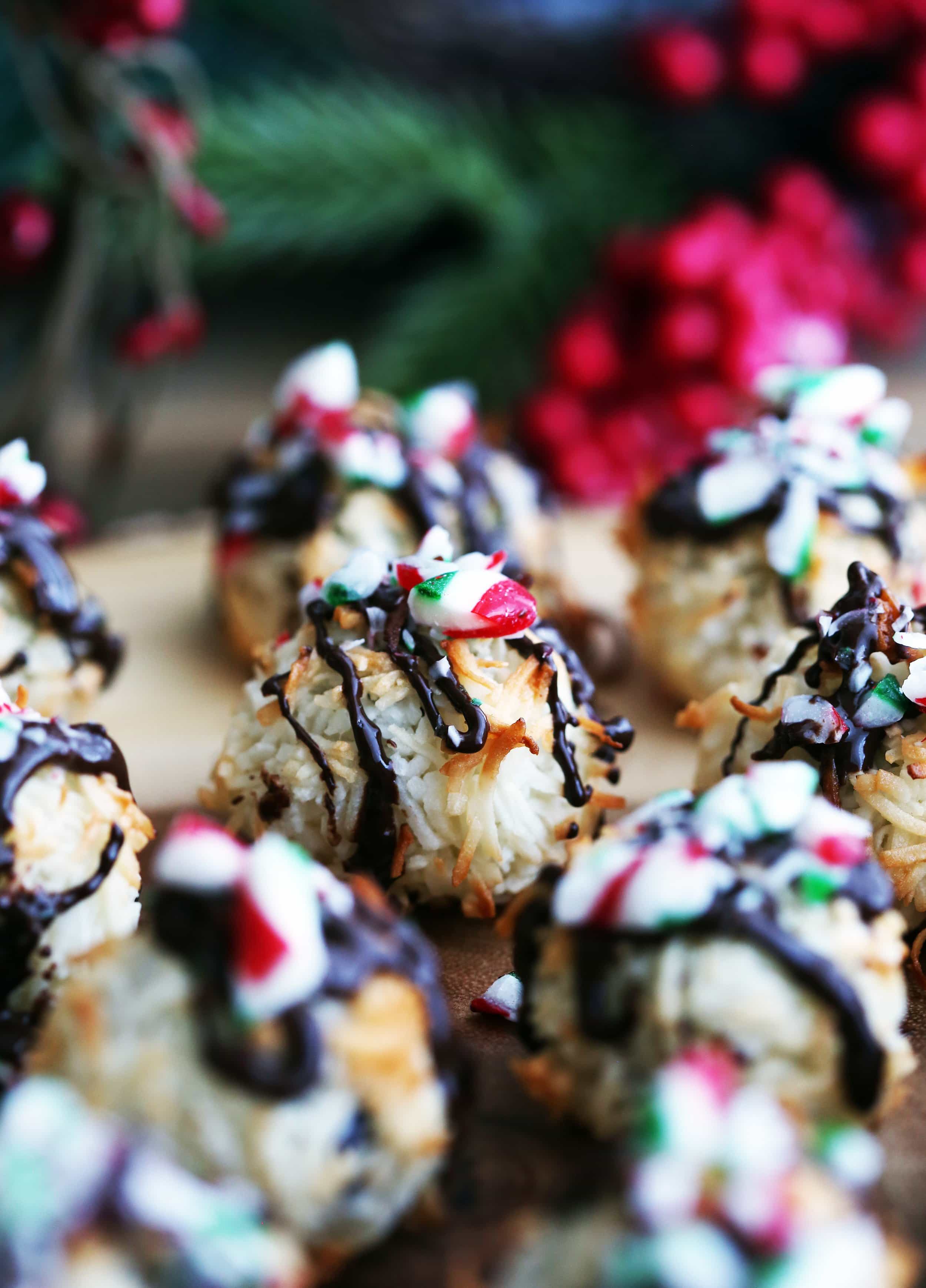 A closeup view of a single Peppermint Chocolate Coconut Macaroon surrounded by more macaroons on a wooden platter.