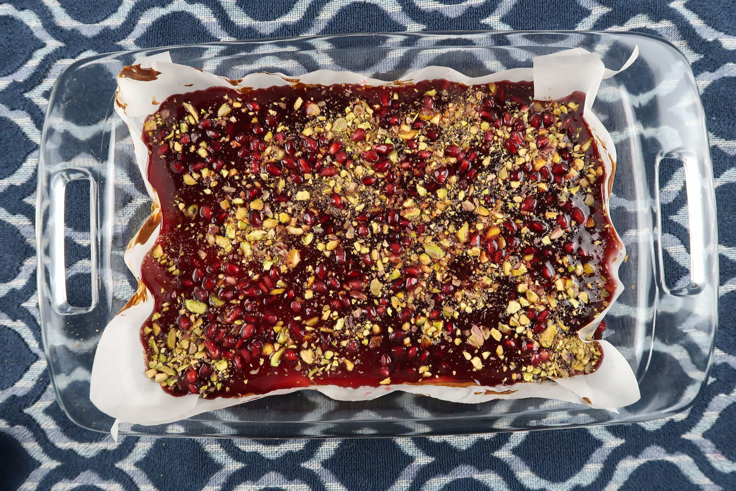 Pomegranate Pistachio Cheesecake Bars in a glass baking dish